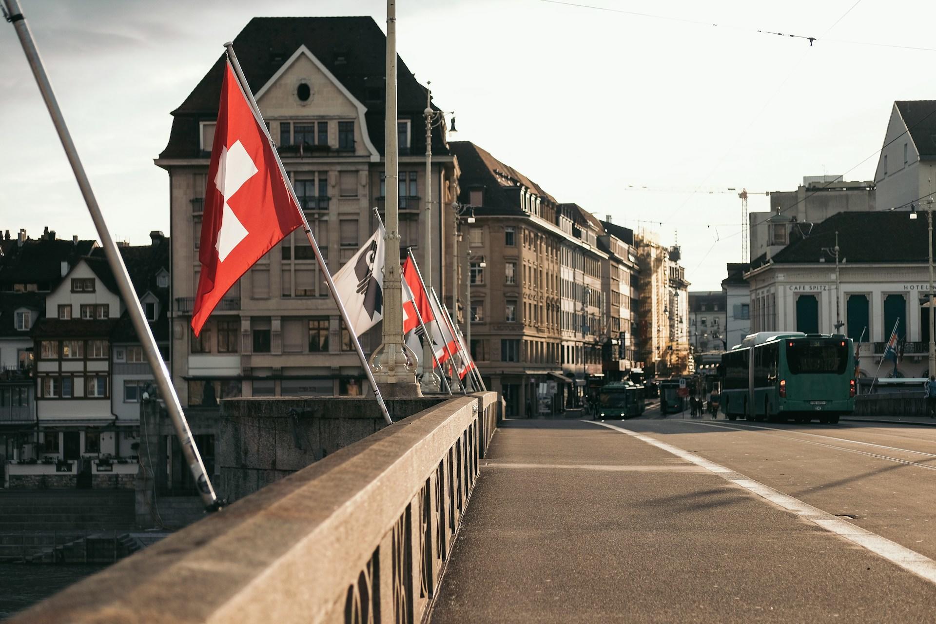 Brücke mit Schweiz Fahnen und Häuserwand.