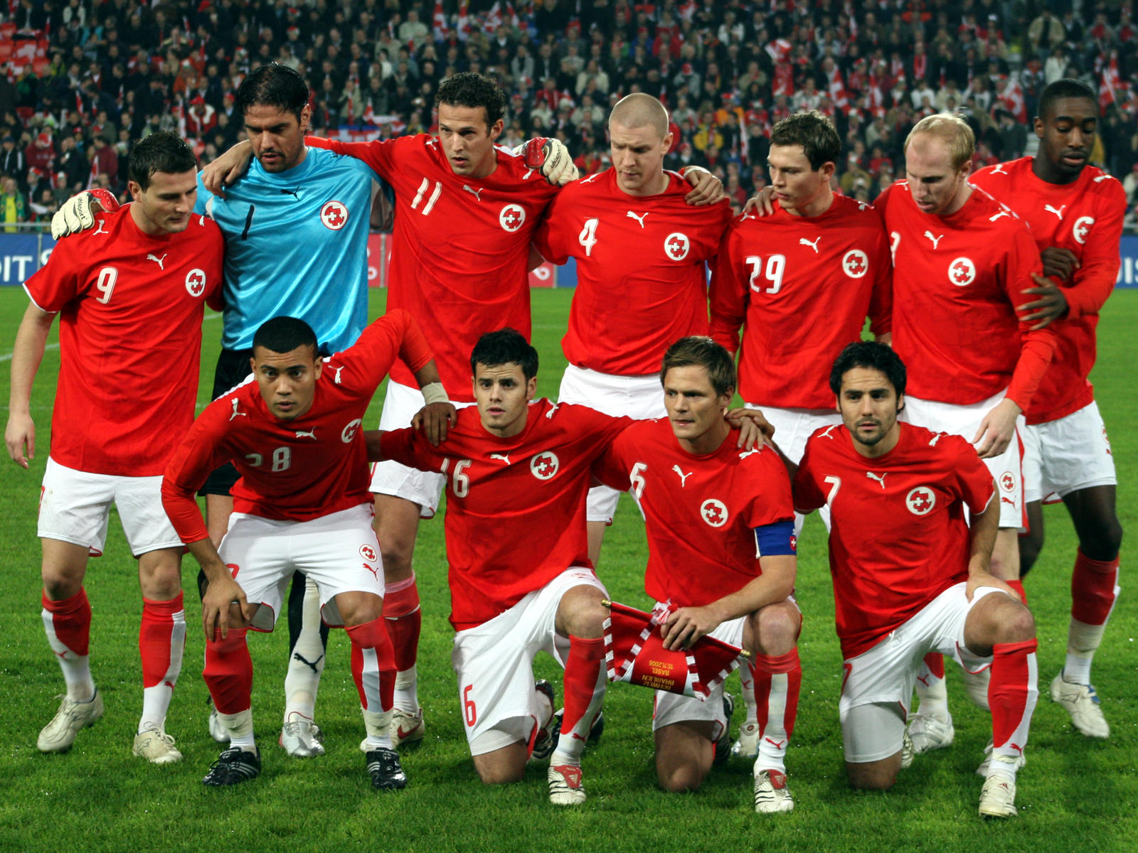 Fussballmannschaft in roten Trikots auf dem Rasen.