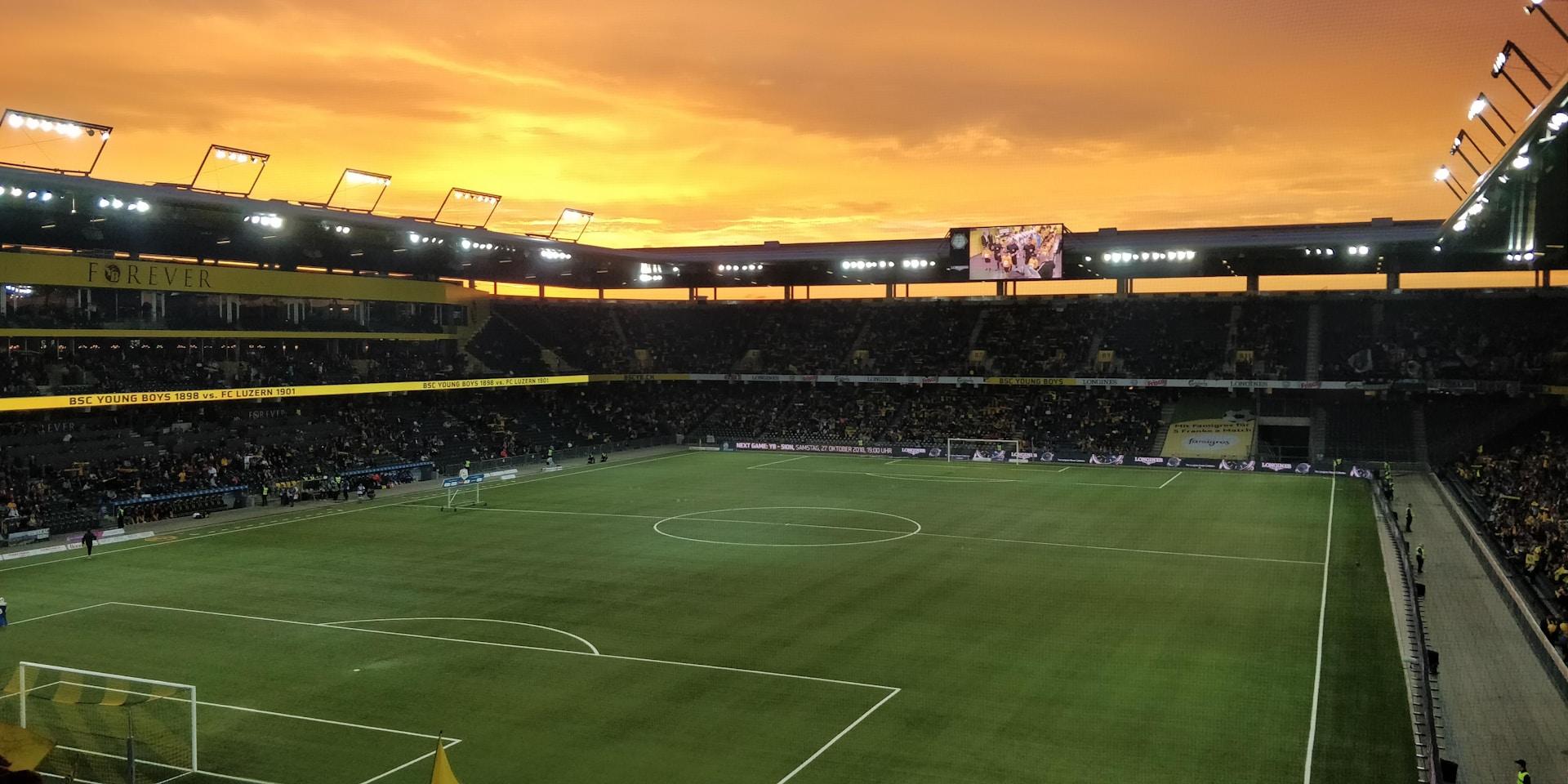 Fussballstadion vor orangenem Himmel.