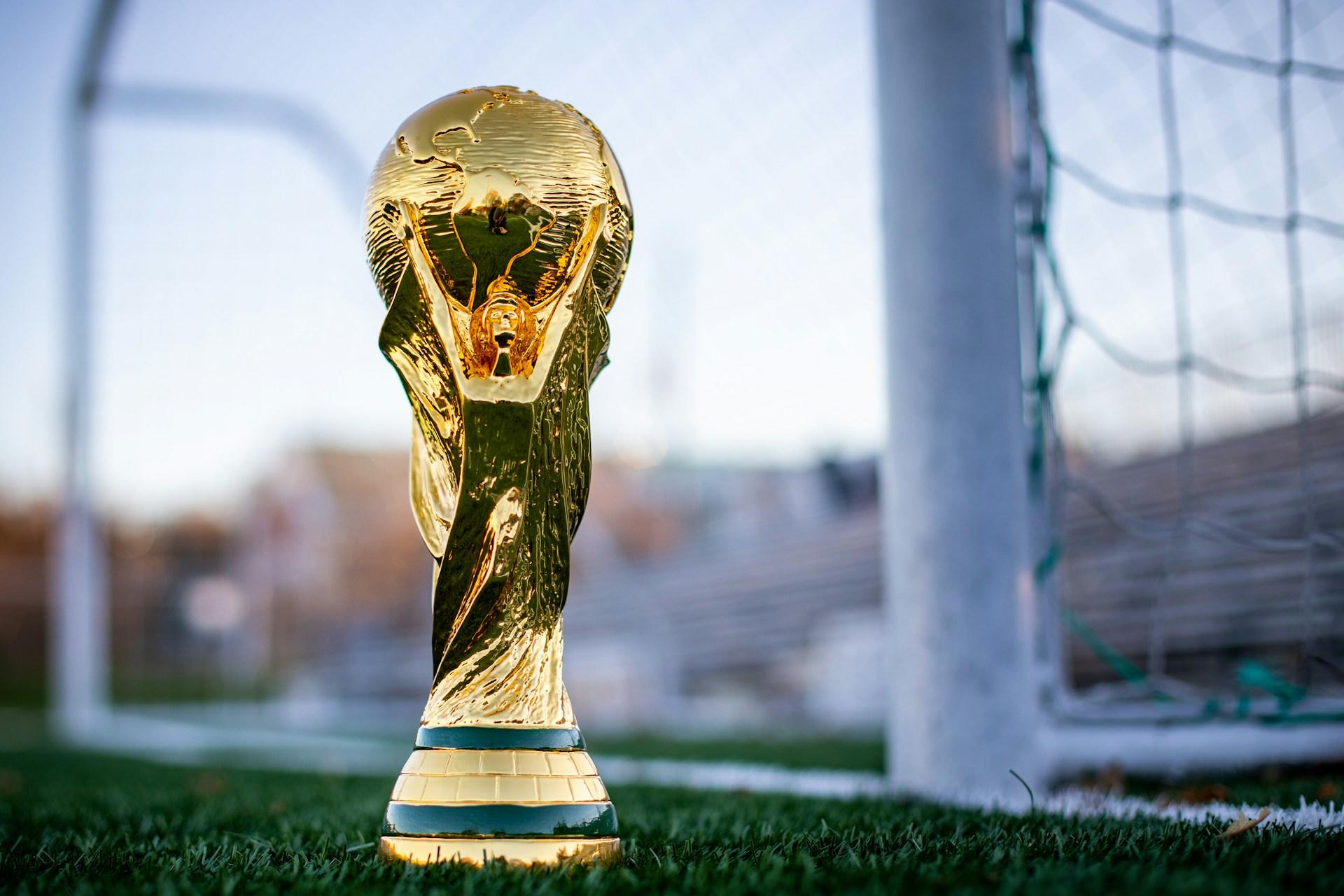 Goldene Trophäe auf Fussballplatz.