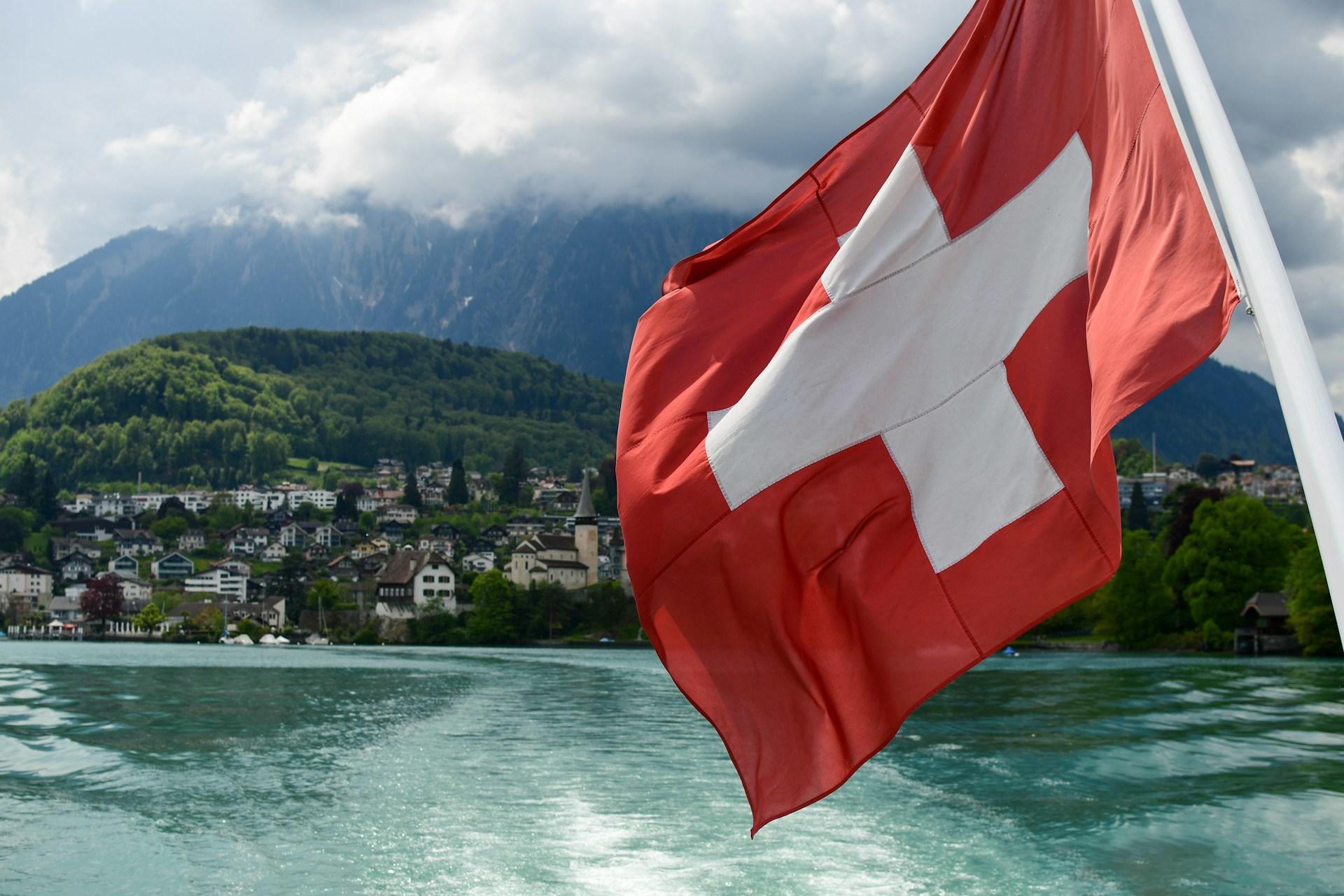 Eine Schweizer Flagge vor idyllischer Landschaft