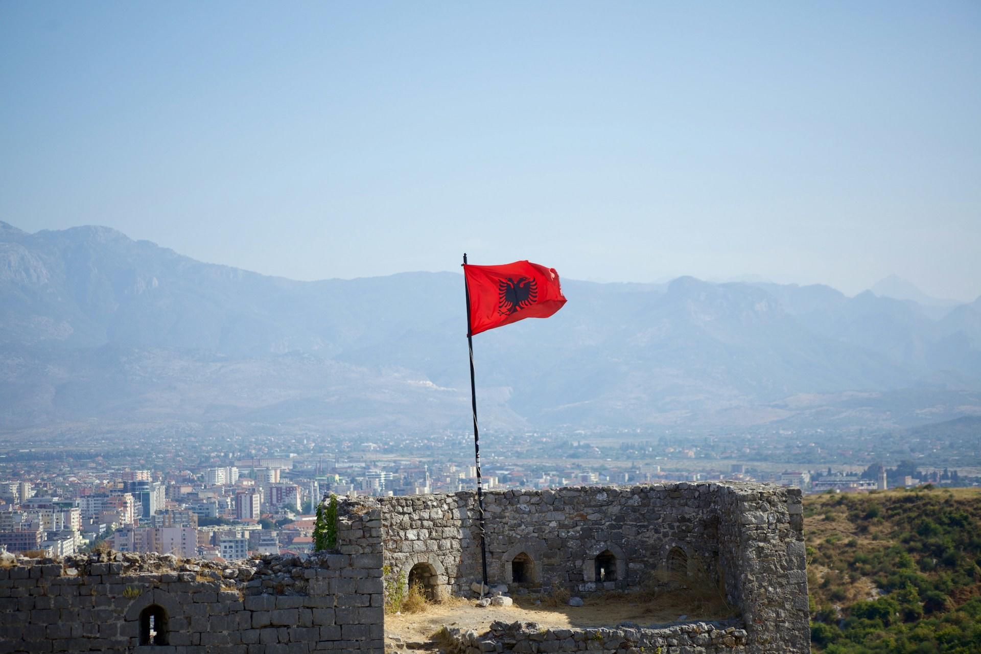 Die Flagge Albaniens weht über einer Burg