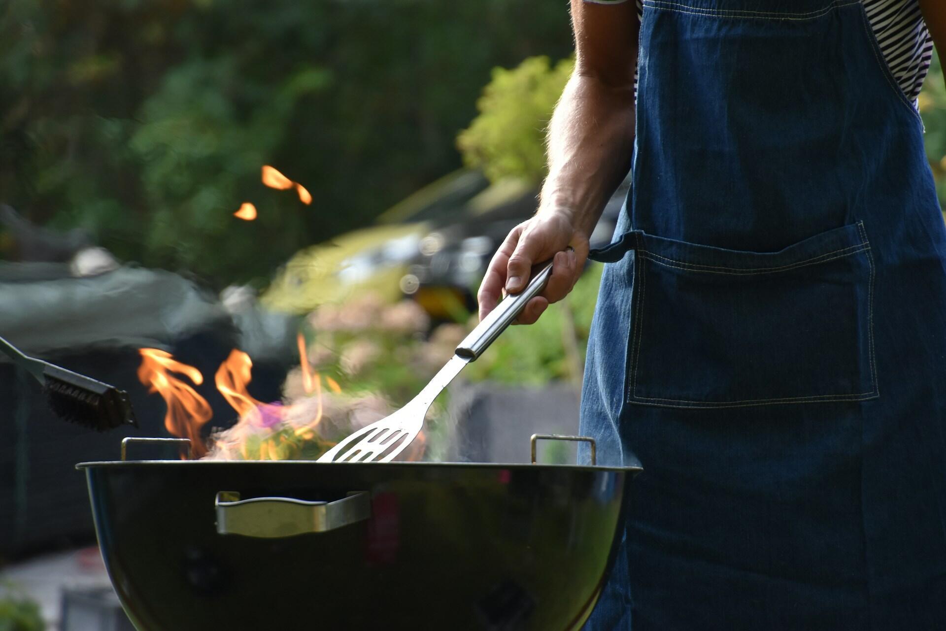 Eine Person steht am Grill