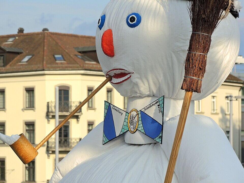 Eine Schneemannfigur mit Fliege, Pfeife und Besen