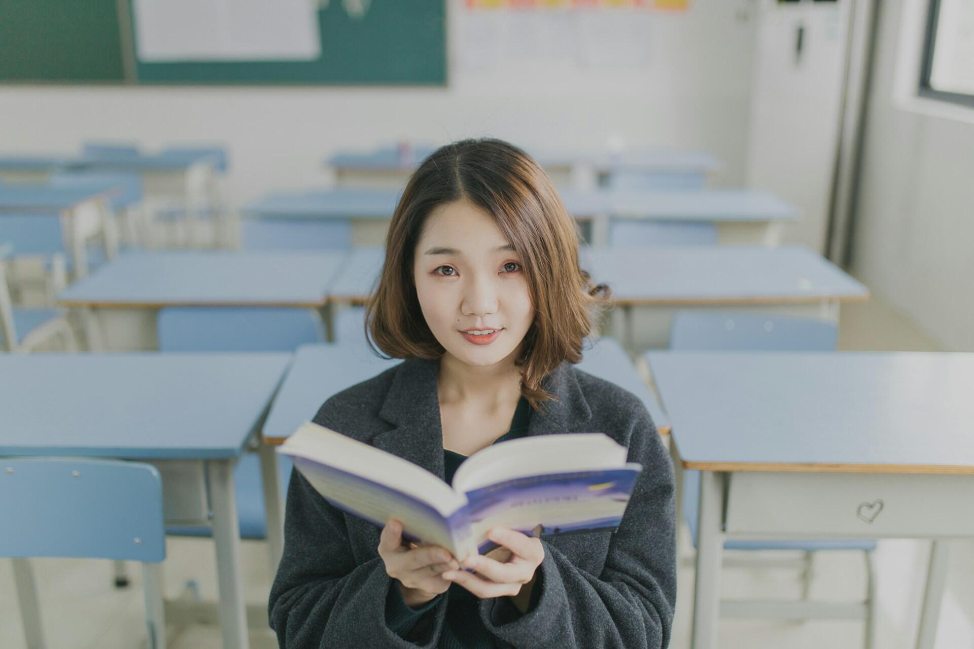 Eine Person mit Buch im Klassenzimmer