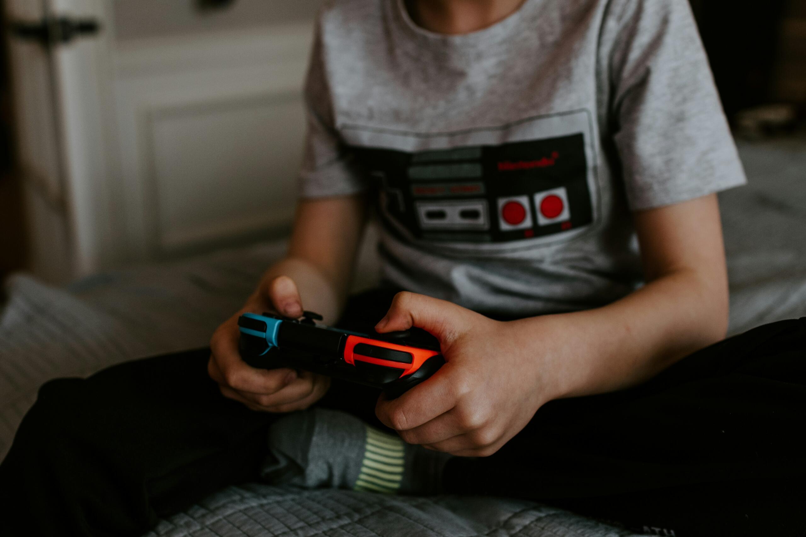Halli särgiga poiss mängib Nintendo videomängu