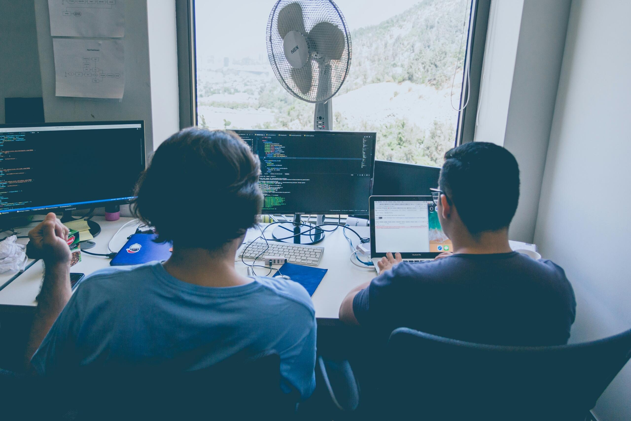 Noorem programmeerija ja mentor arutavad koodi üle