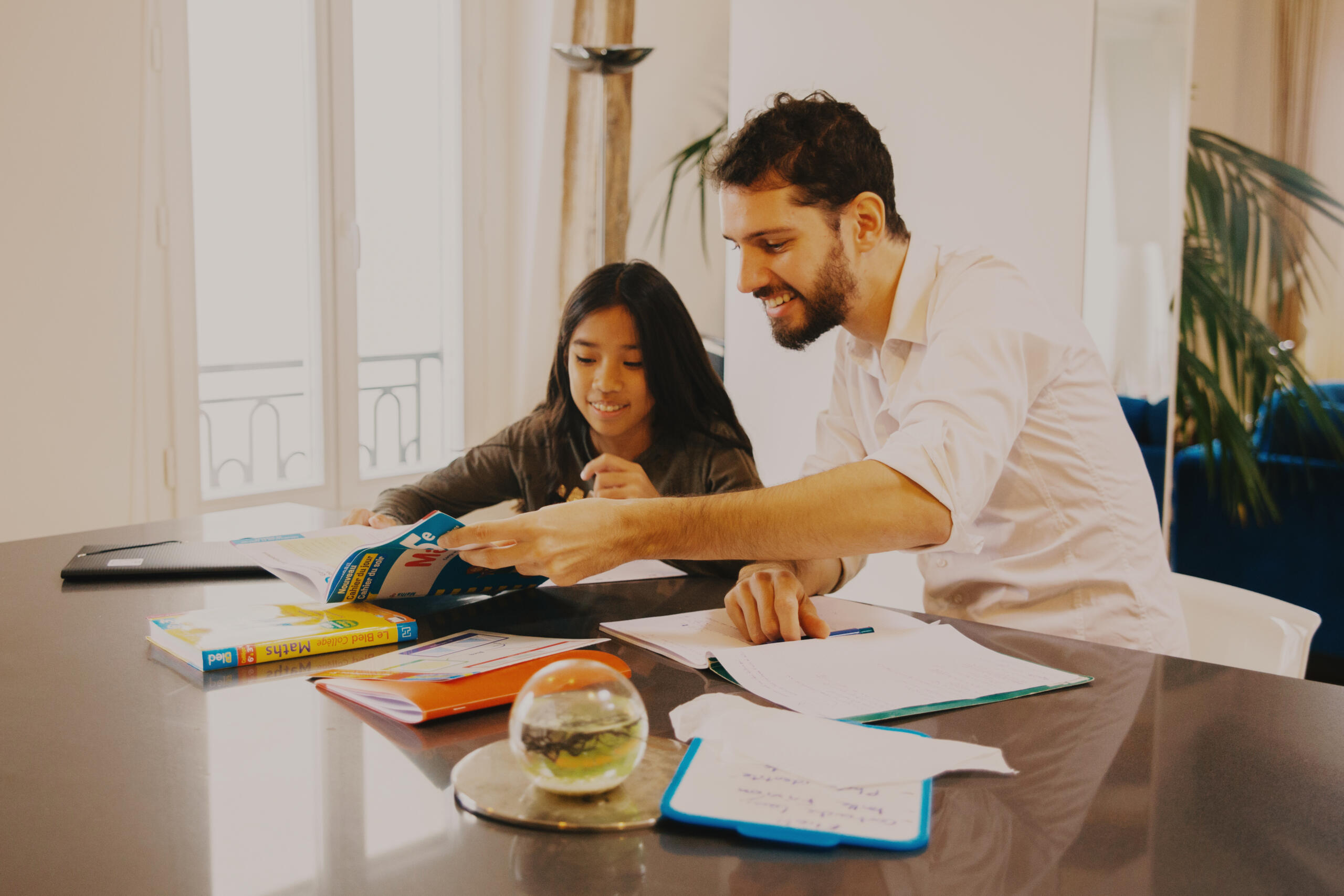 Mees ja tüdruk laua taga kooliõpikuid vaatamas