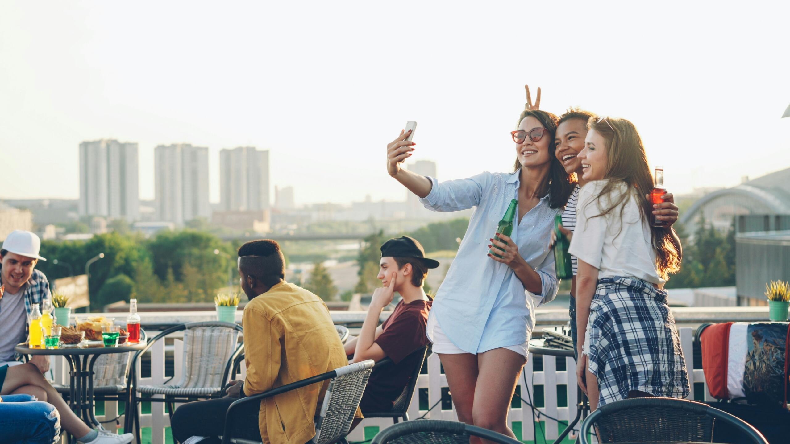 Sõbrad veedavad aega katuseterrassil ja teevad telefoniga selfit