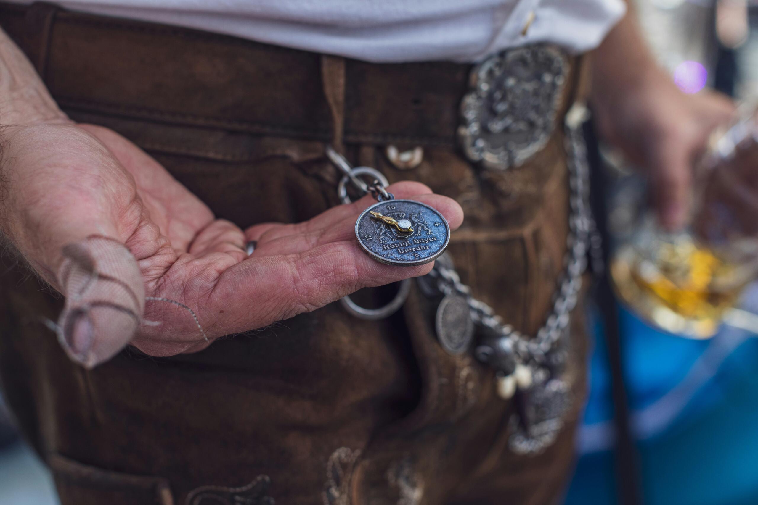 Mees kannab Baieri rahvarõivaid ehk lederhosen’e ja hoiab käes traditsioonilist taskukella