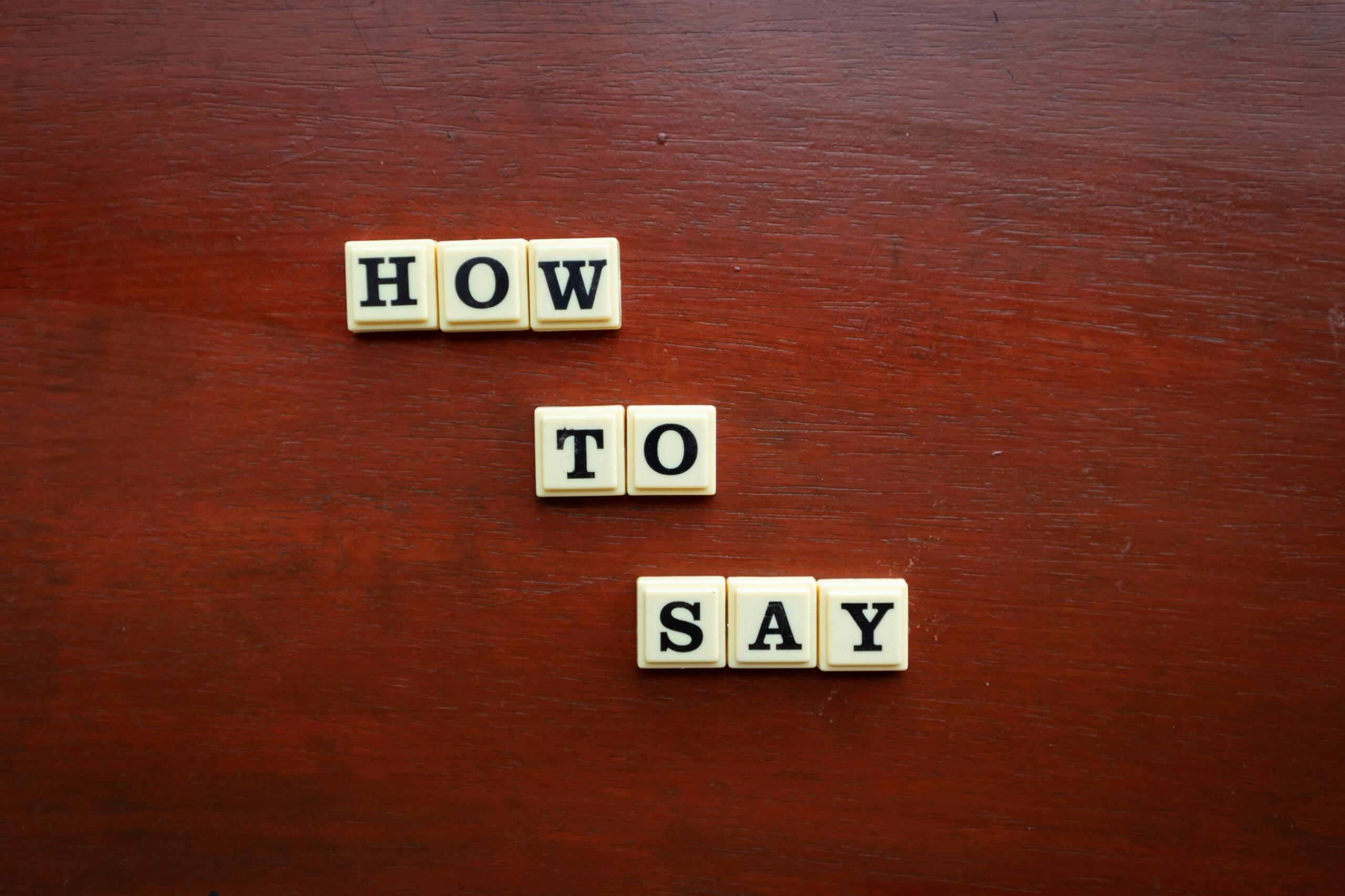 scrabble’i tähtedest moodustatud fraas „how to say” puidust pinnal