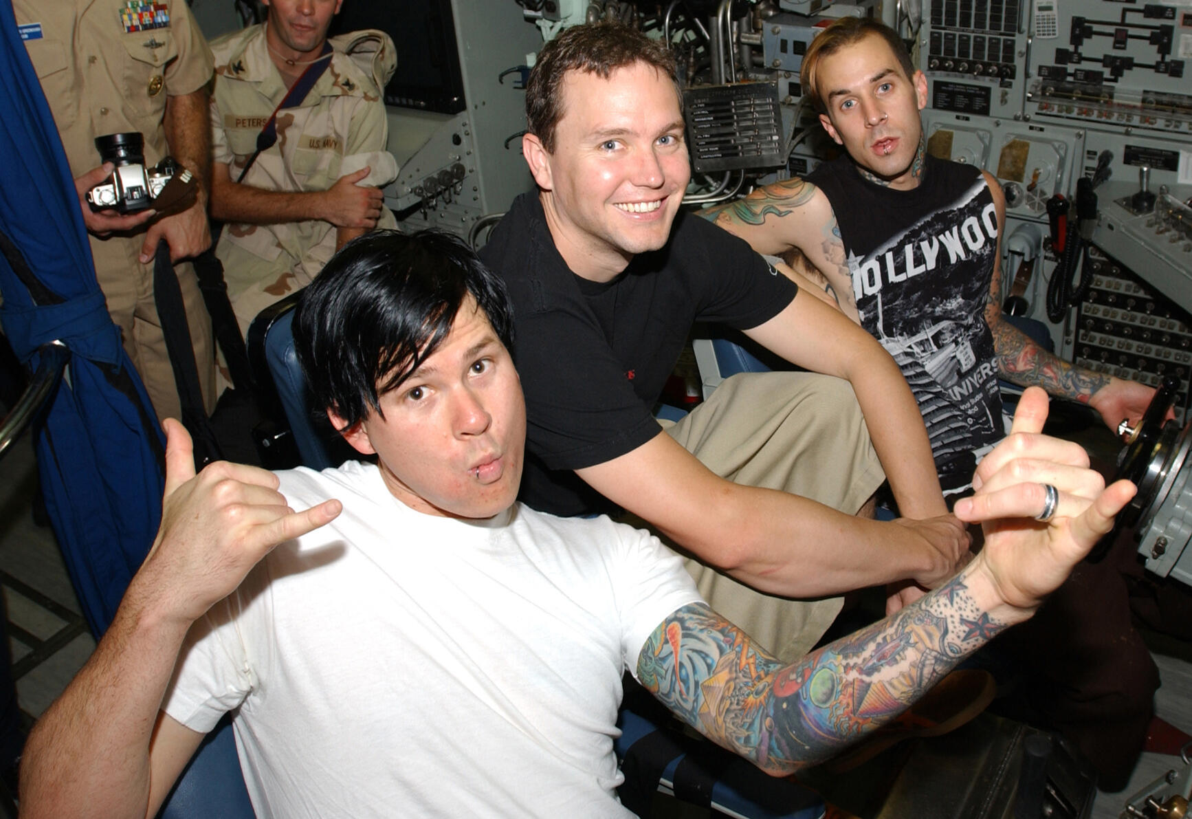 Blink-182 liikmed Tom DeLonge, Mark Hoppus ja Travis Barker istuvad allveelaeva juhtimisruumis ning vaatavad kaamera poole.