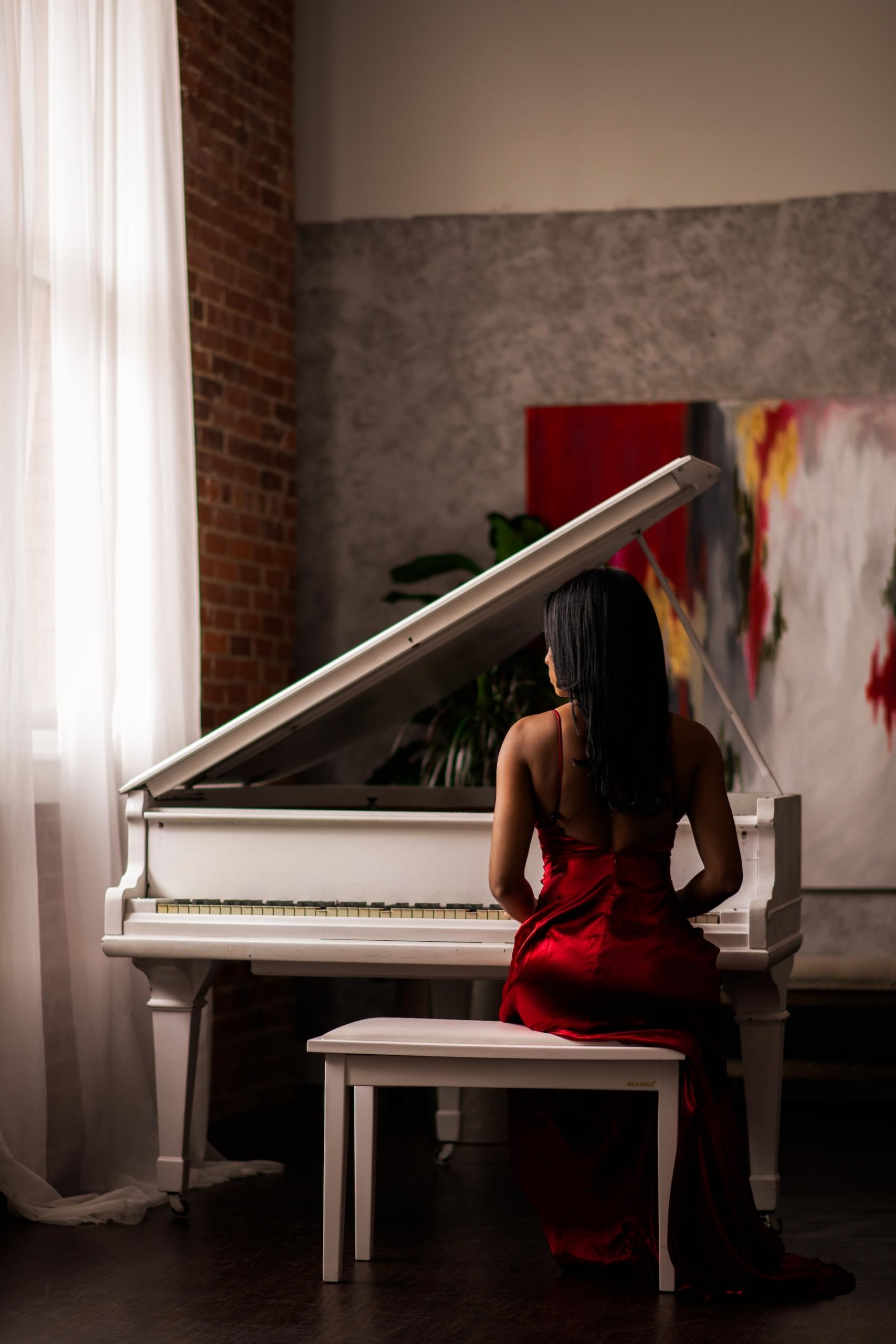 Persona sentada ante un piano de cola.