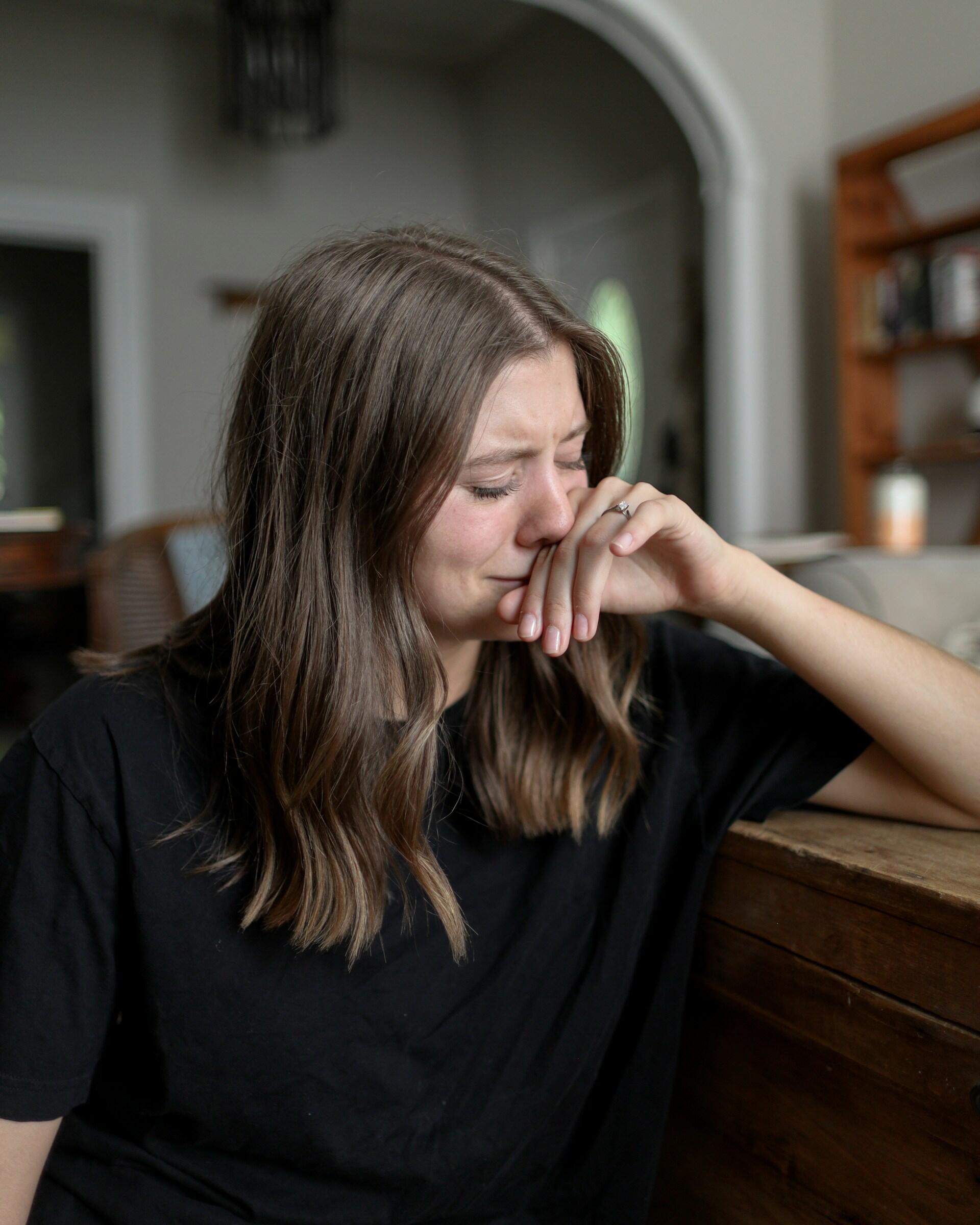Chica llorando en casa.