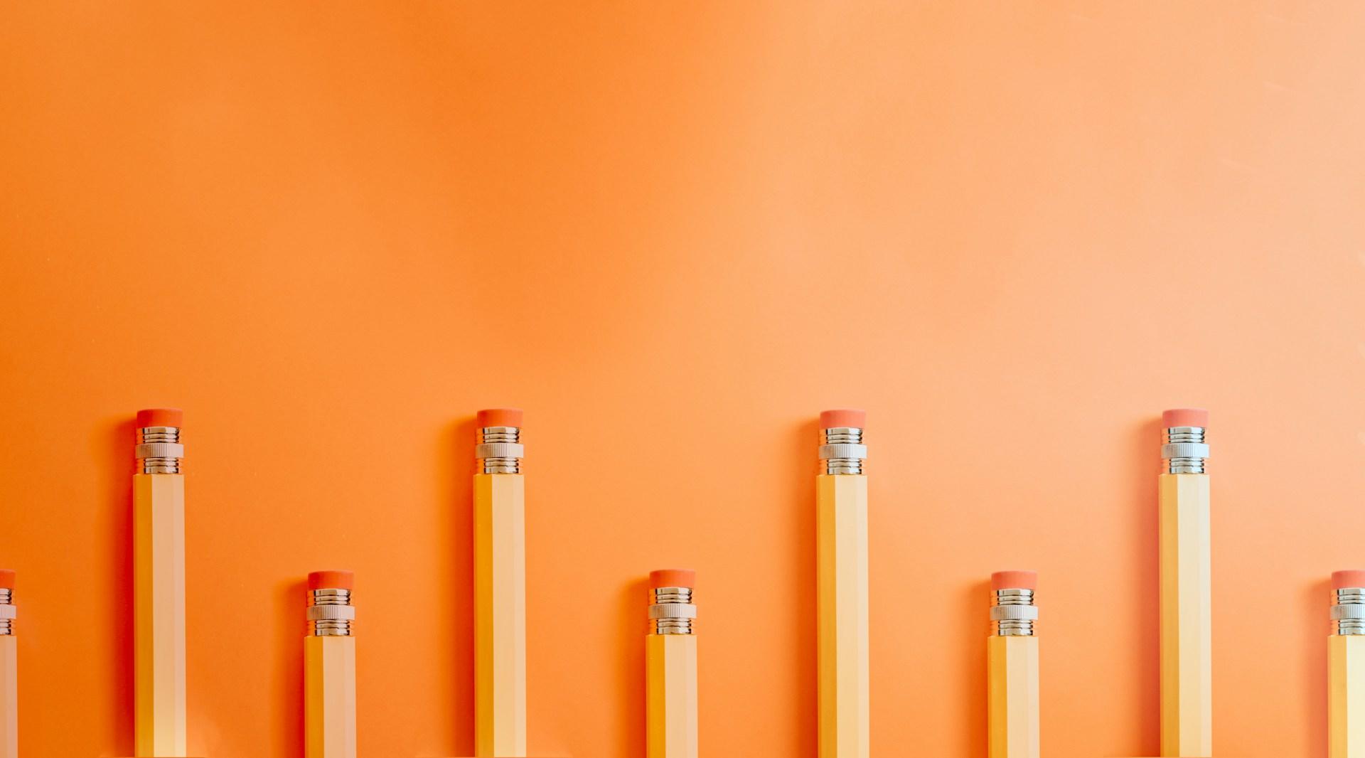 imagen pop de fondo color naranja con lápices escolares amarillos
