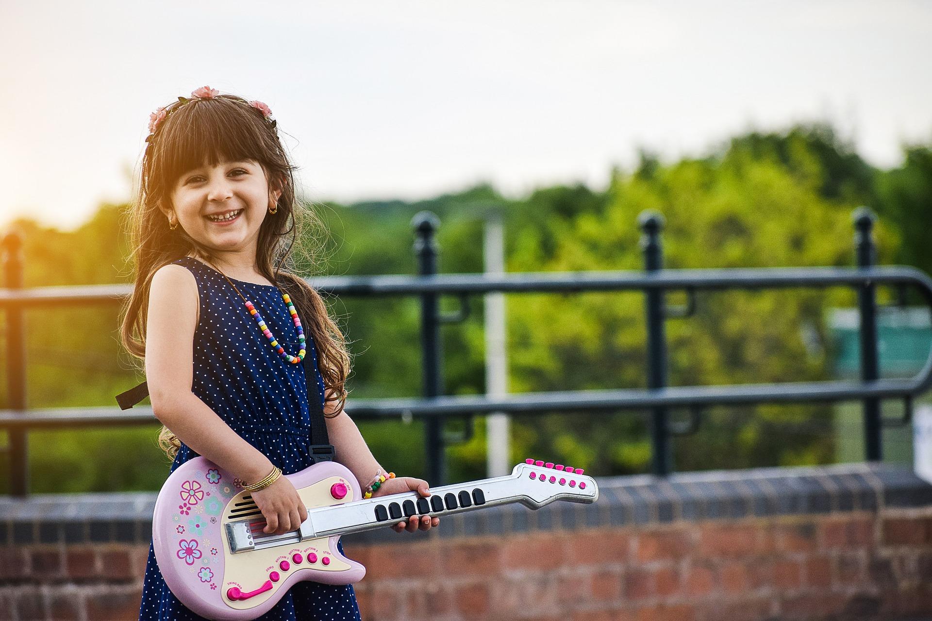 niña pequeña con una guitarra de juguete