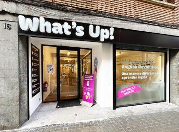 Fachada de un centro de enseñanza de inglés llamado «What's Up!», con grandes ventanales, un letrero moderno y una entrada acogedora. Ambiente luminoso y atractivo.