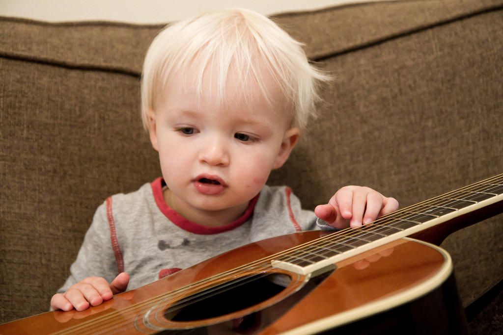Niño pequeño con una guitarra.