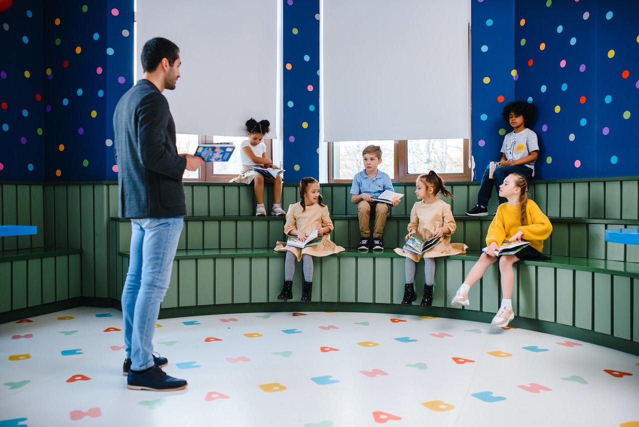 Profesor dando clase a niños pequeños.