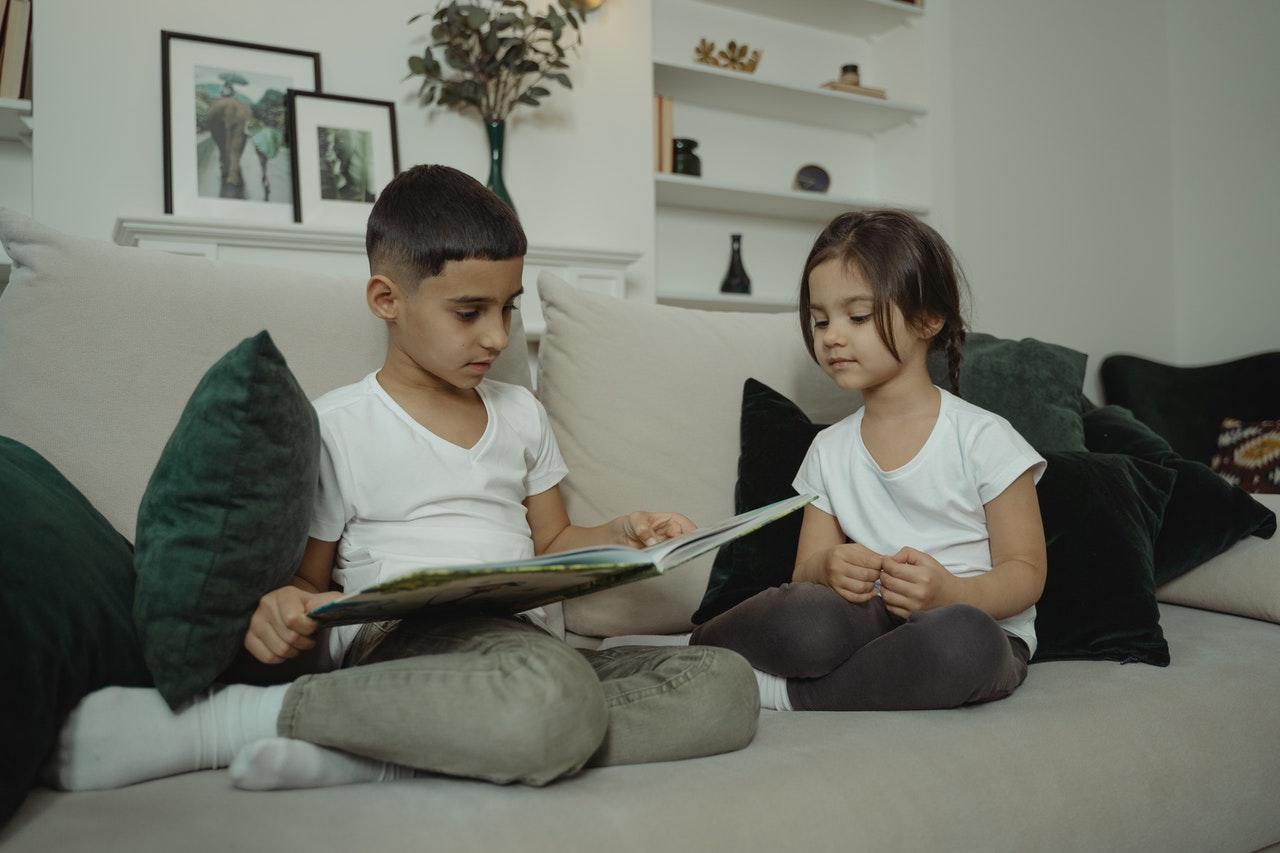 Niños leyendo en el sofá.