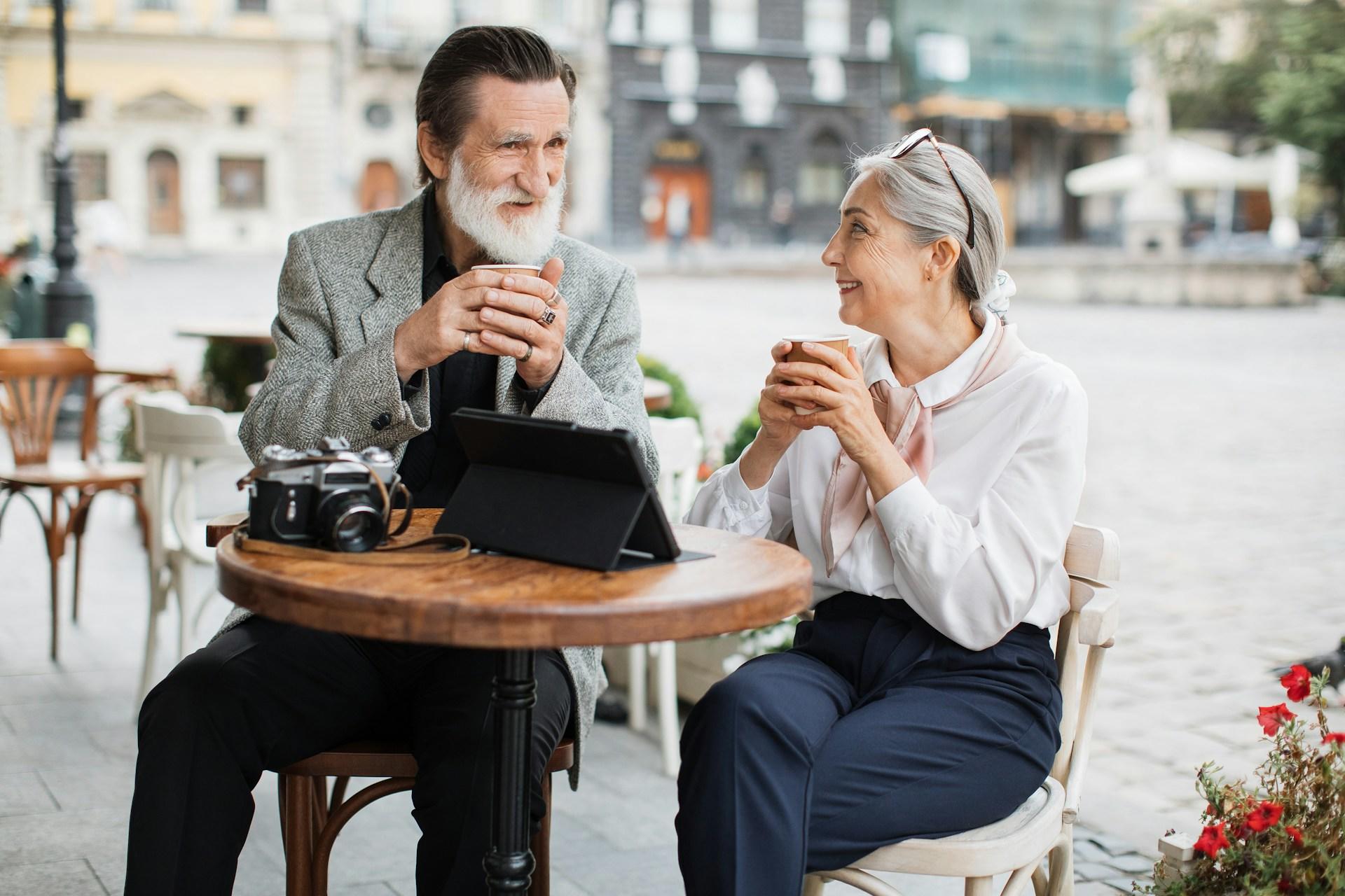 una pareja jubilada disfrutando de un rico café en el centro.