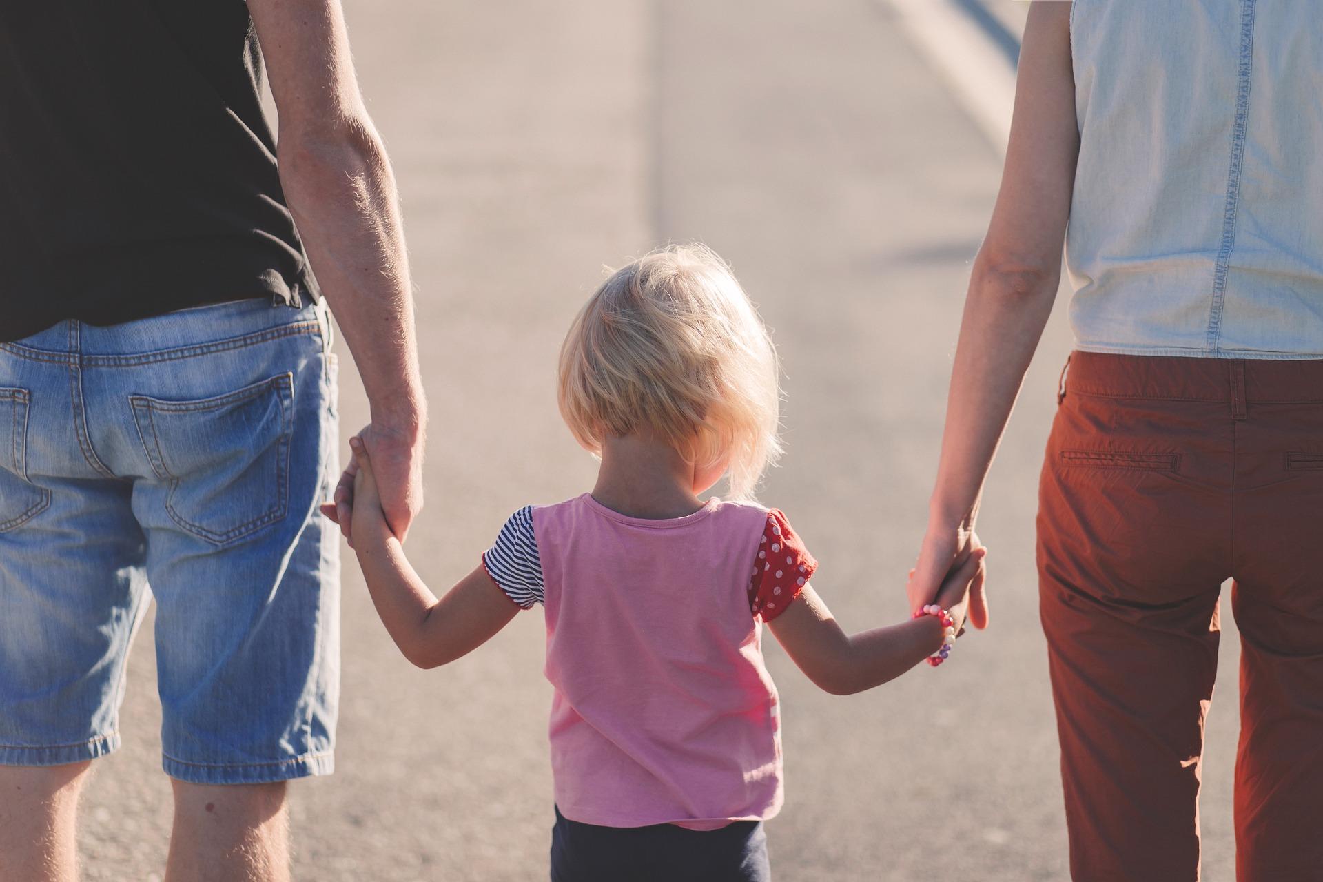 Adultos con un niño de la mano.