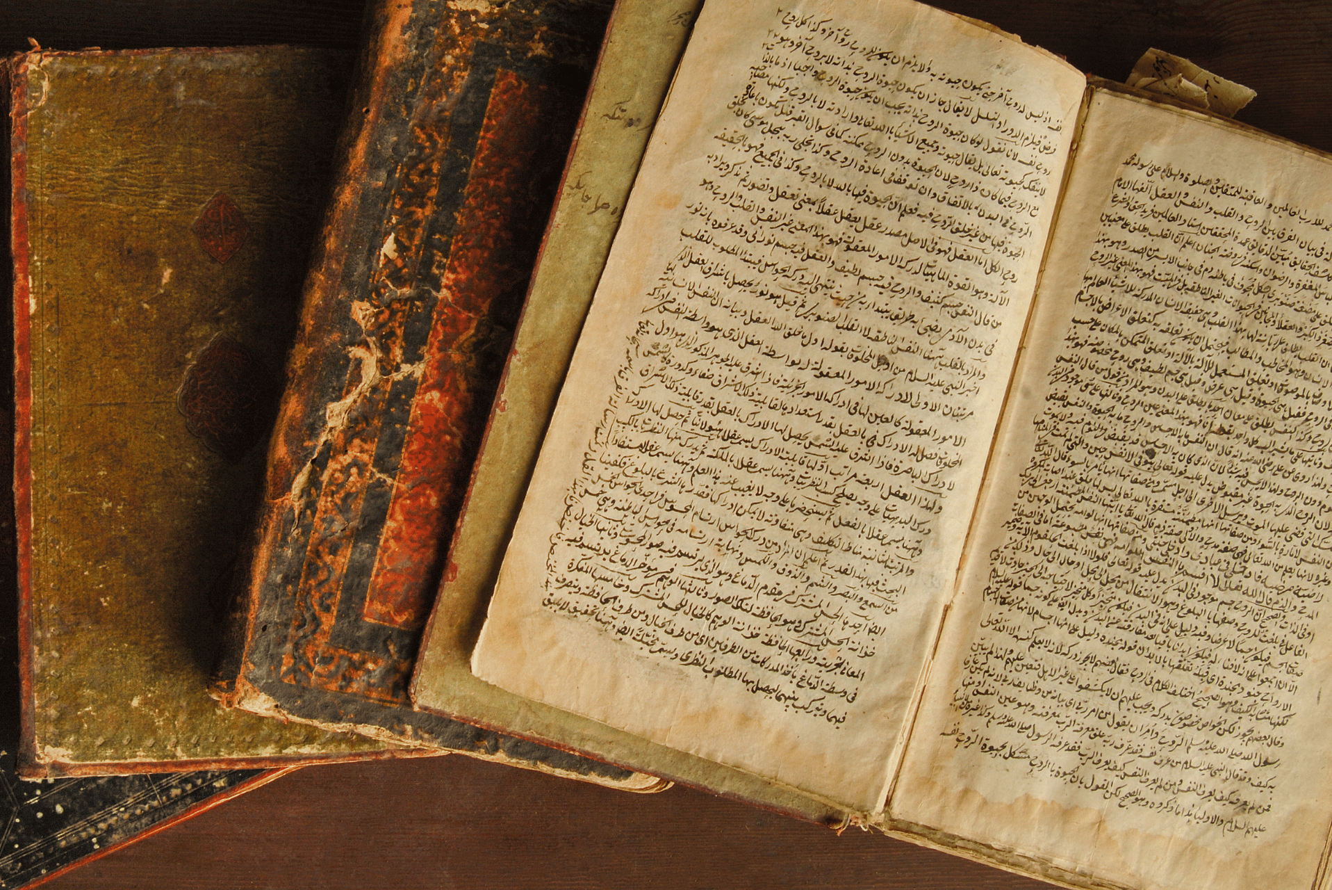 varios libros viejos en árabe cerrados y uno abierto
