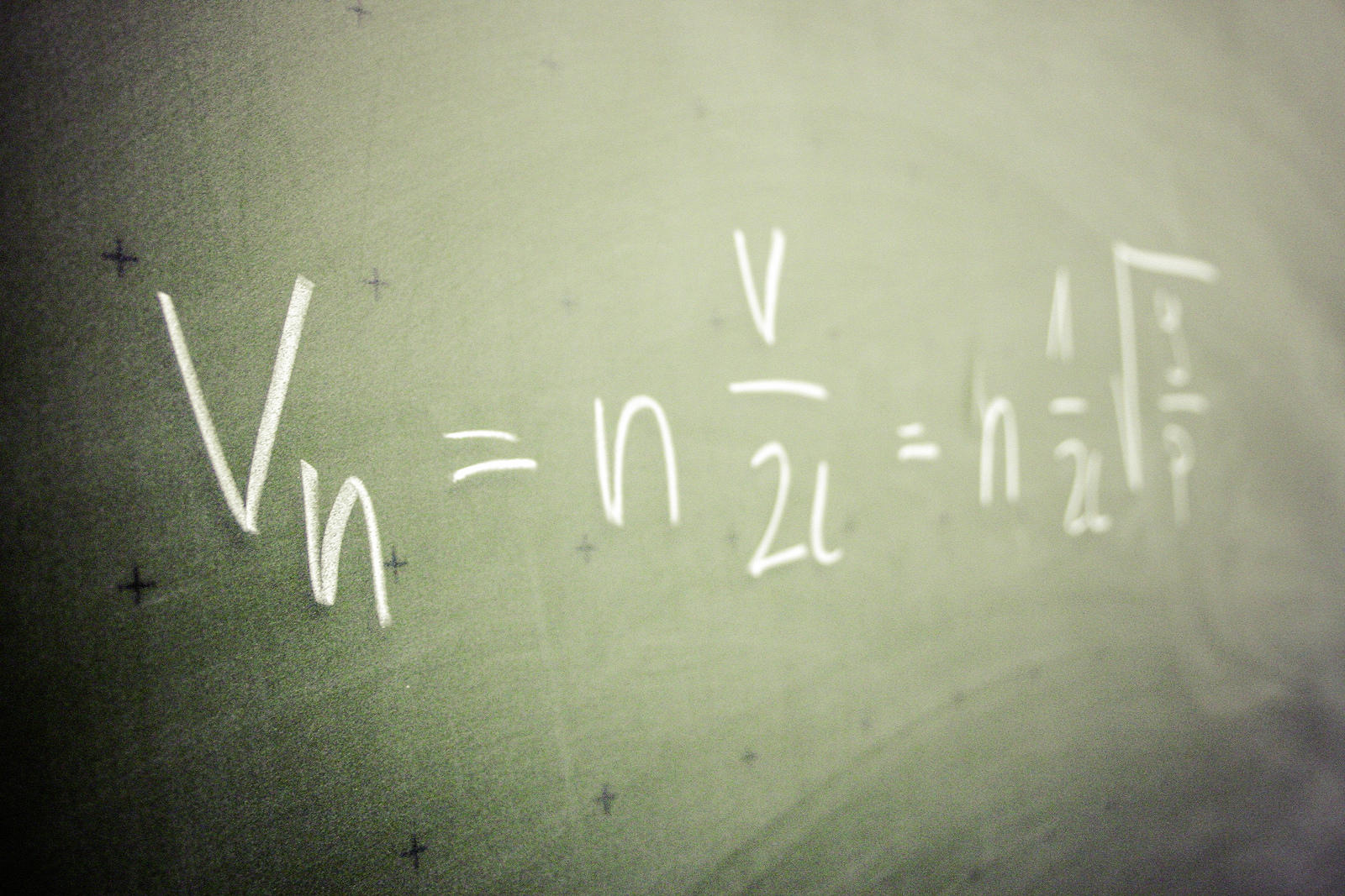 pizarron verde con una fórmula matemática escrita a tiza