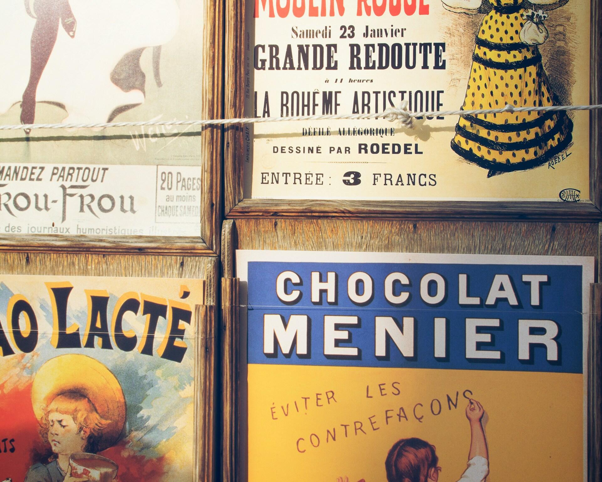 Un collage formado por carteles publicitarios franceses de época: el letrero de Chocolate Menier, una bailarina del Moulin Rouge y coloridas ilustraciones crean un ambiente nostálgico.