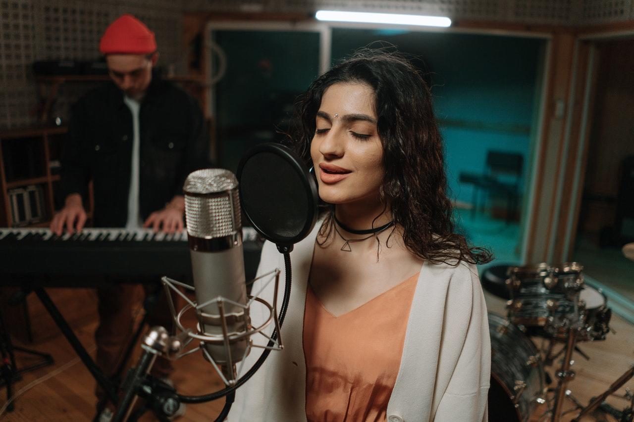 Chica grabando una canción en un estudio.