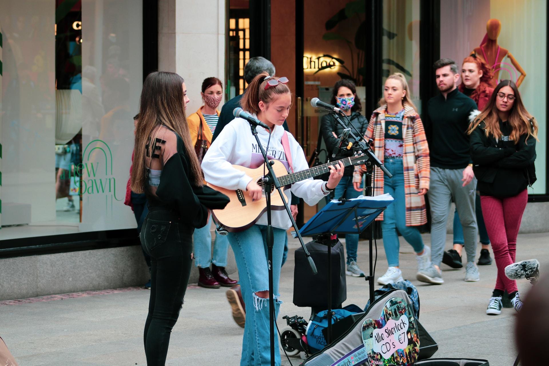 Dos chicas cantando en la calle.
