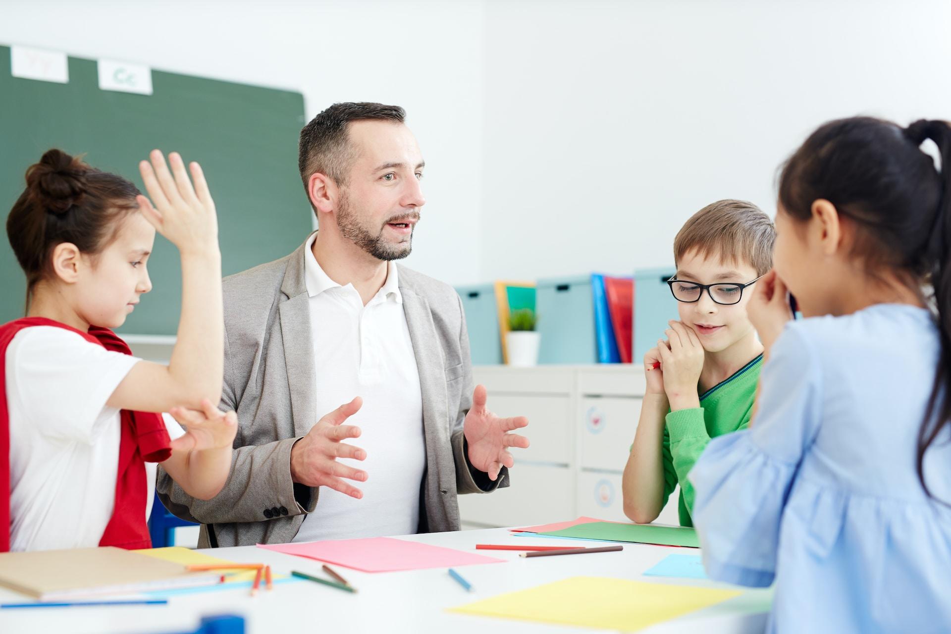 Profesor dando clase a niños de primaria.