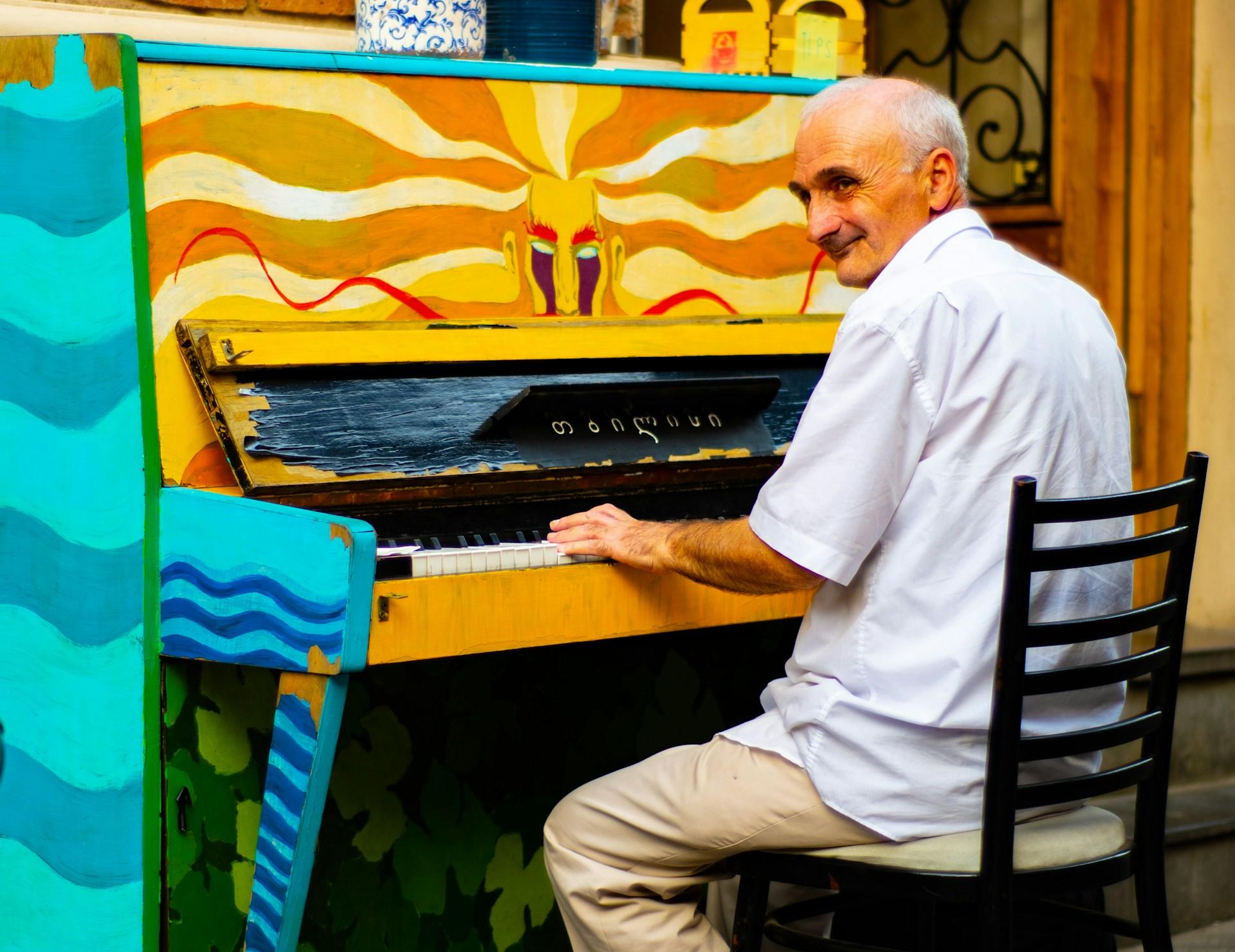 Señor tocando un piano de colorines.