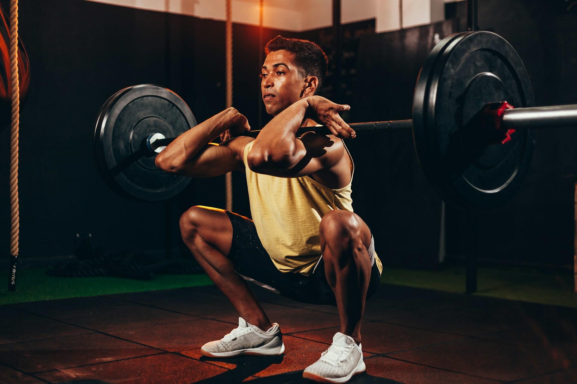 Chico haciendo sentadillas con peso.