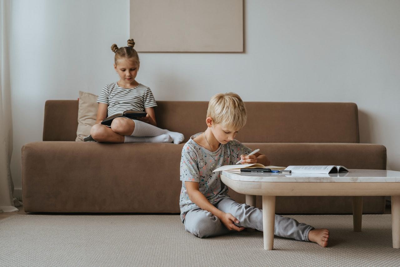 Niños leyendo en el sofá.