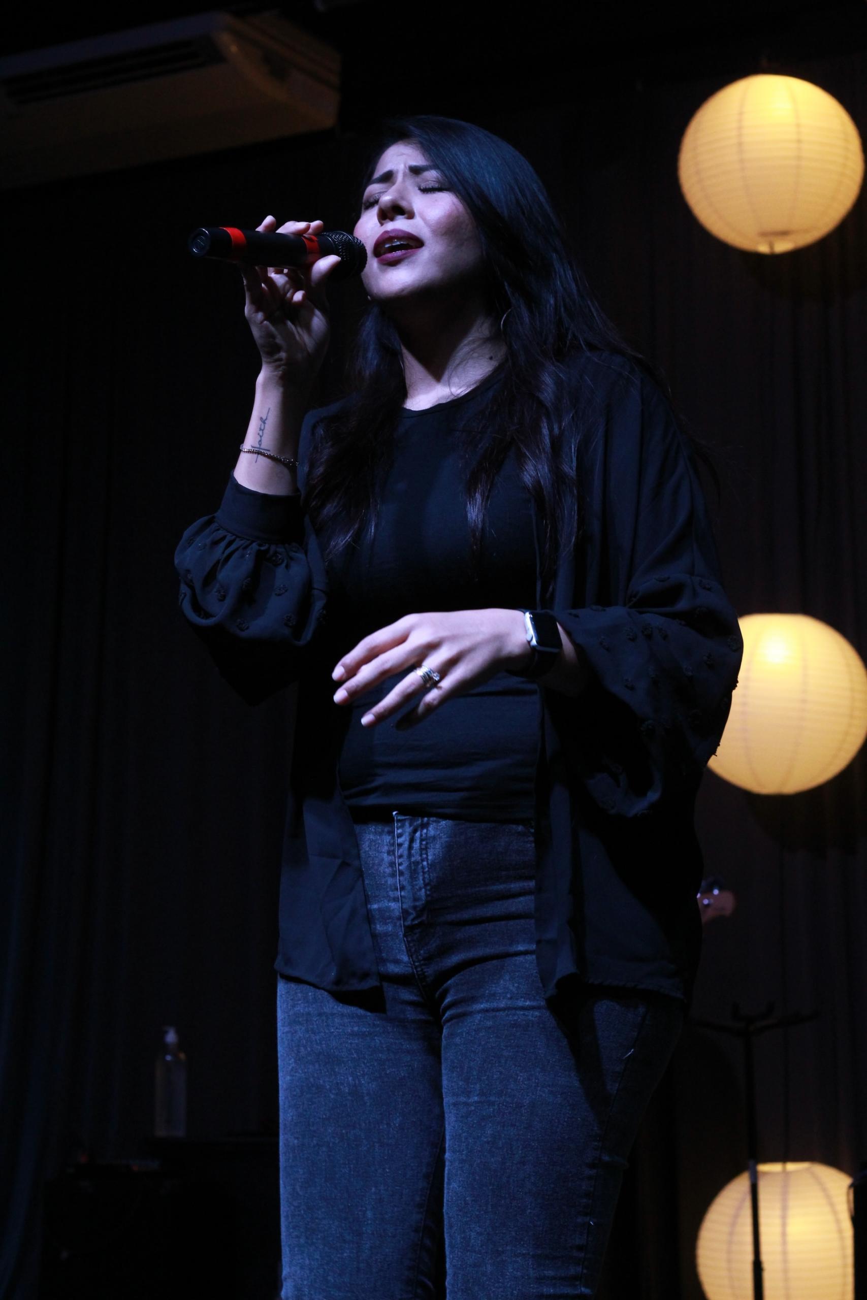 Mujer cantando sobre un escenario.