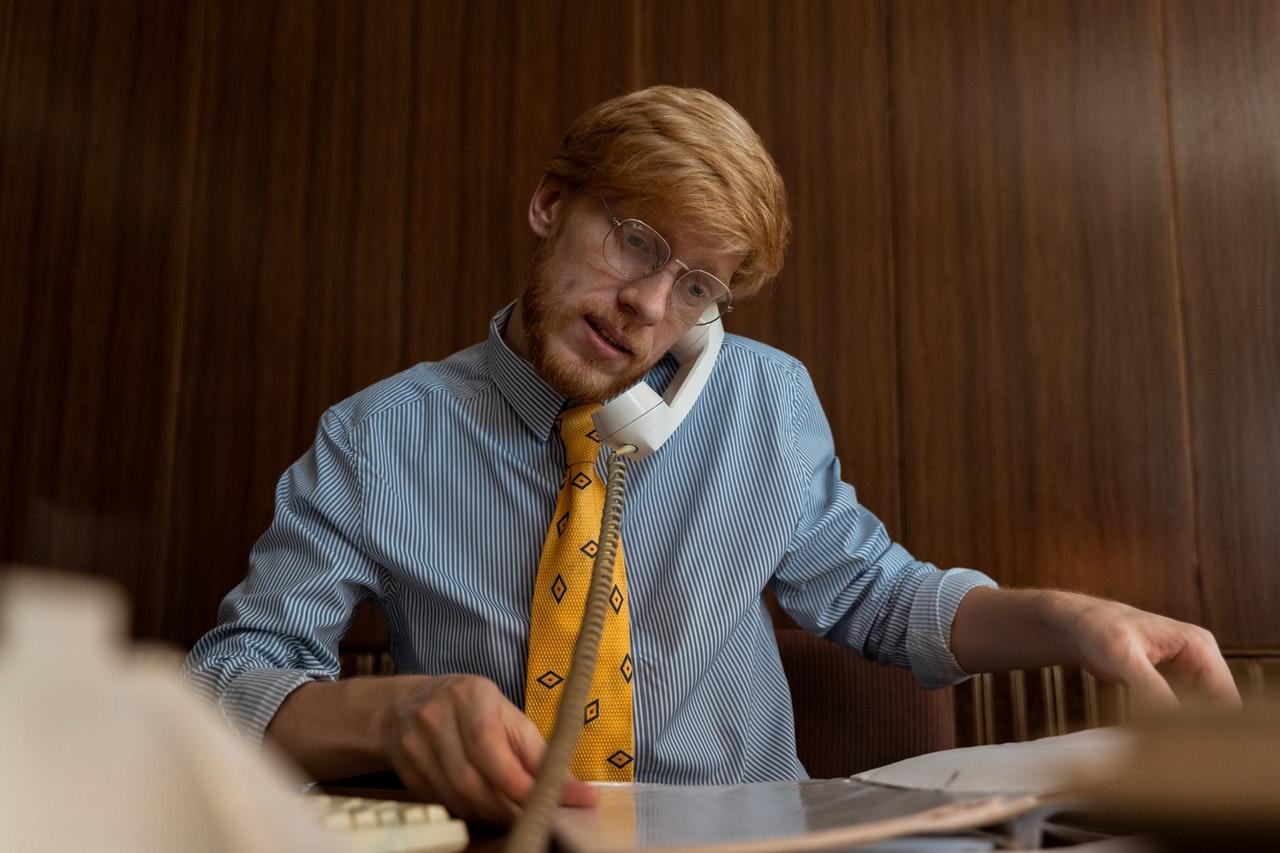 Hombre pelirrojo hablando por teléfono.