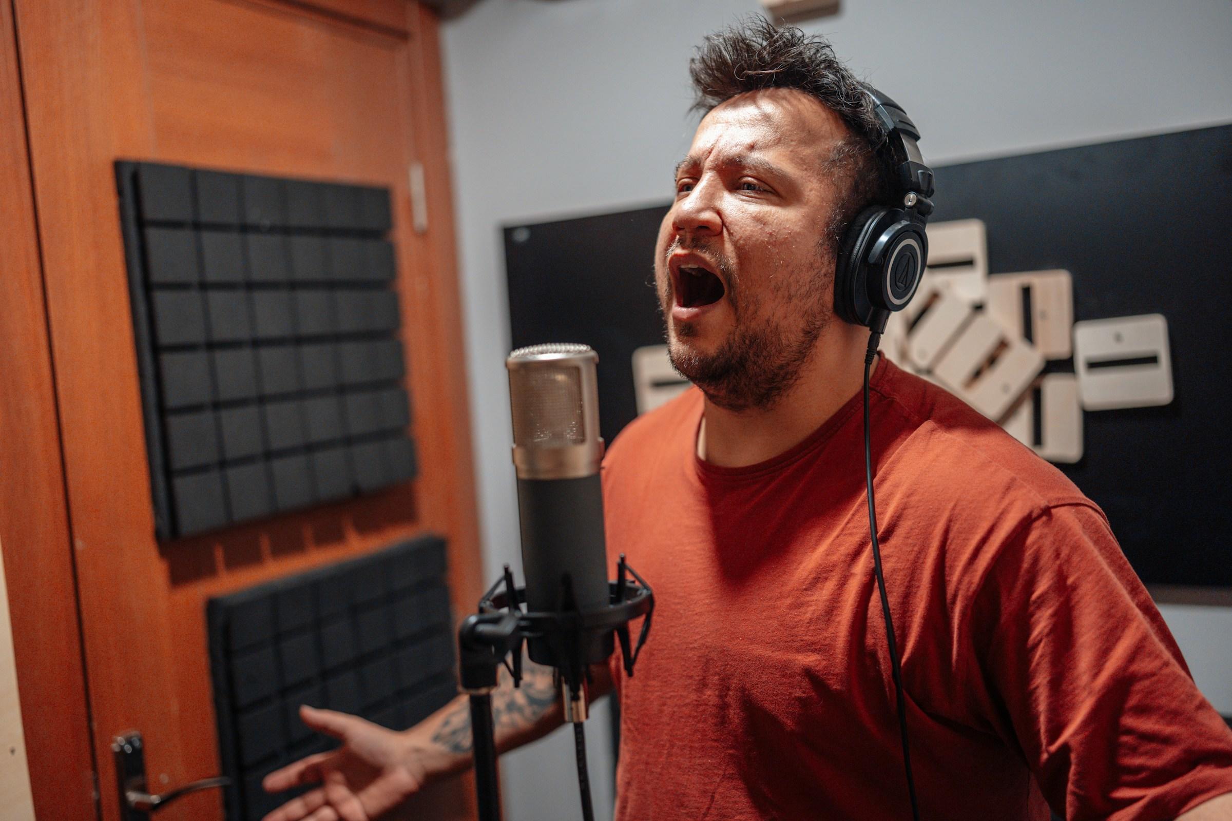 Hombre cantando en un estudio de grabación