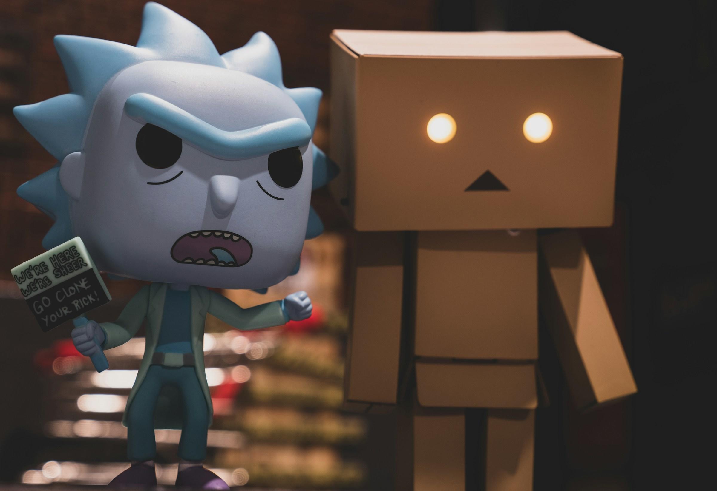 Figura del personaje Rick y Morty junto a una figura robótica de cartón con ojos brillantes.