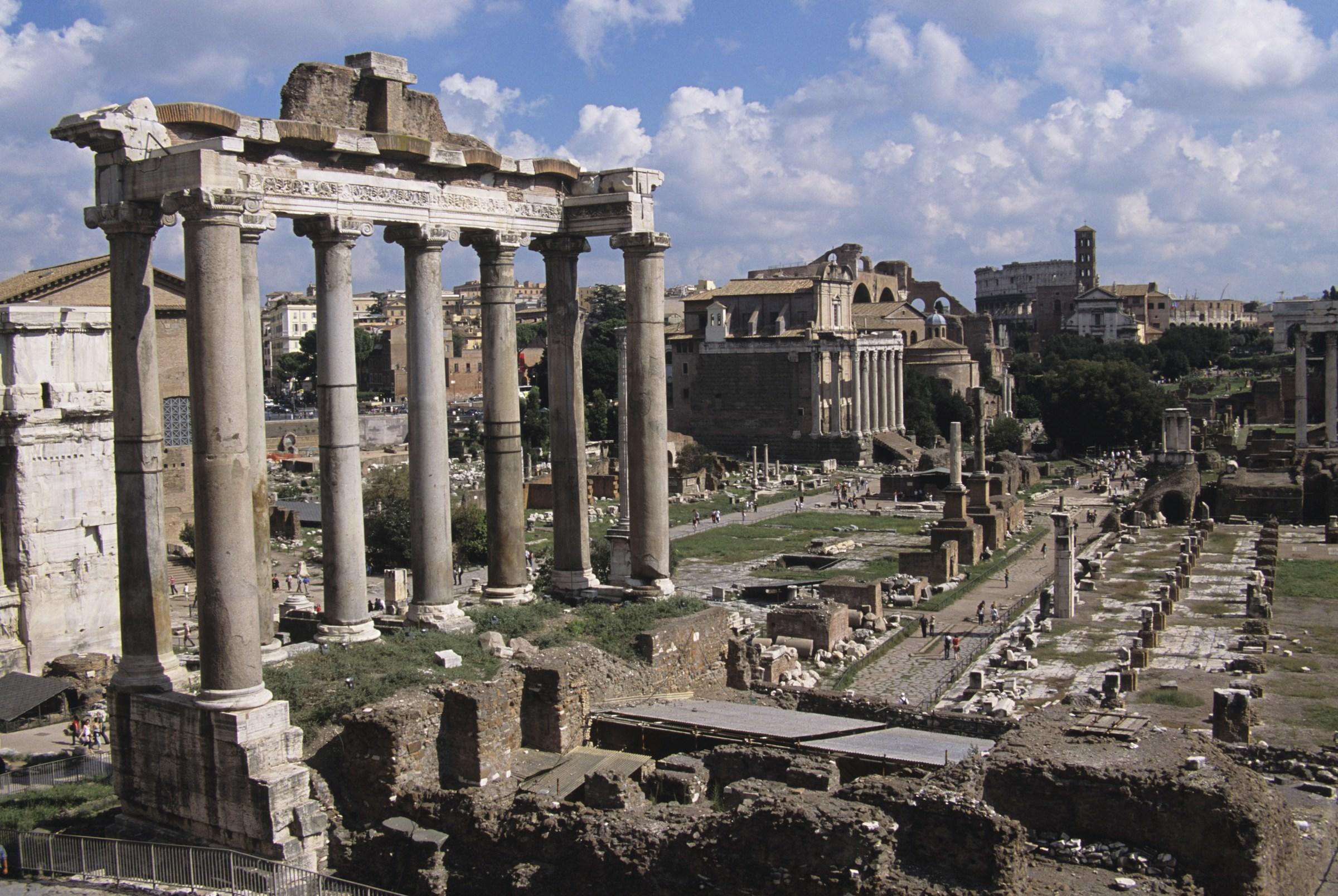 Antiguas ruinas romanas, incluidos el Foro y el Templo de Saturno, bajo un cielo despejado.