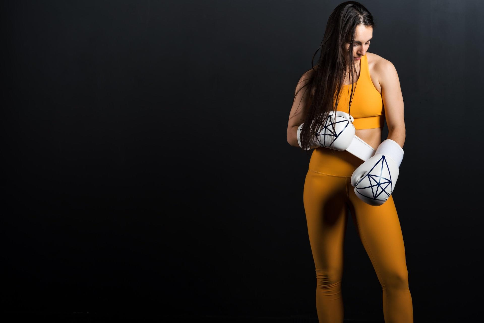 Chica poniéndose los guantes de boxeo.