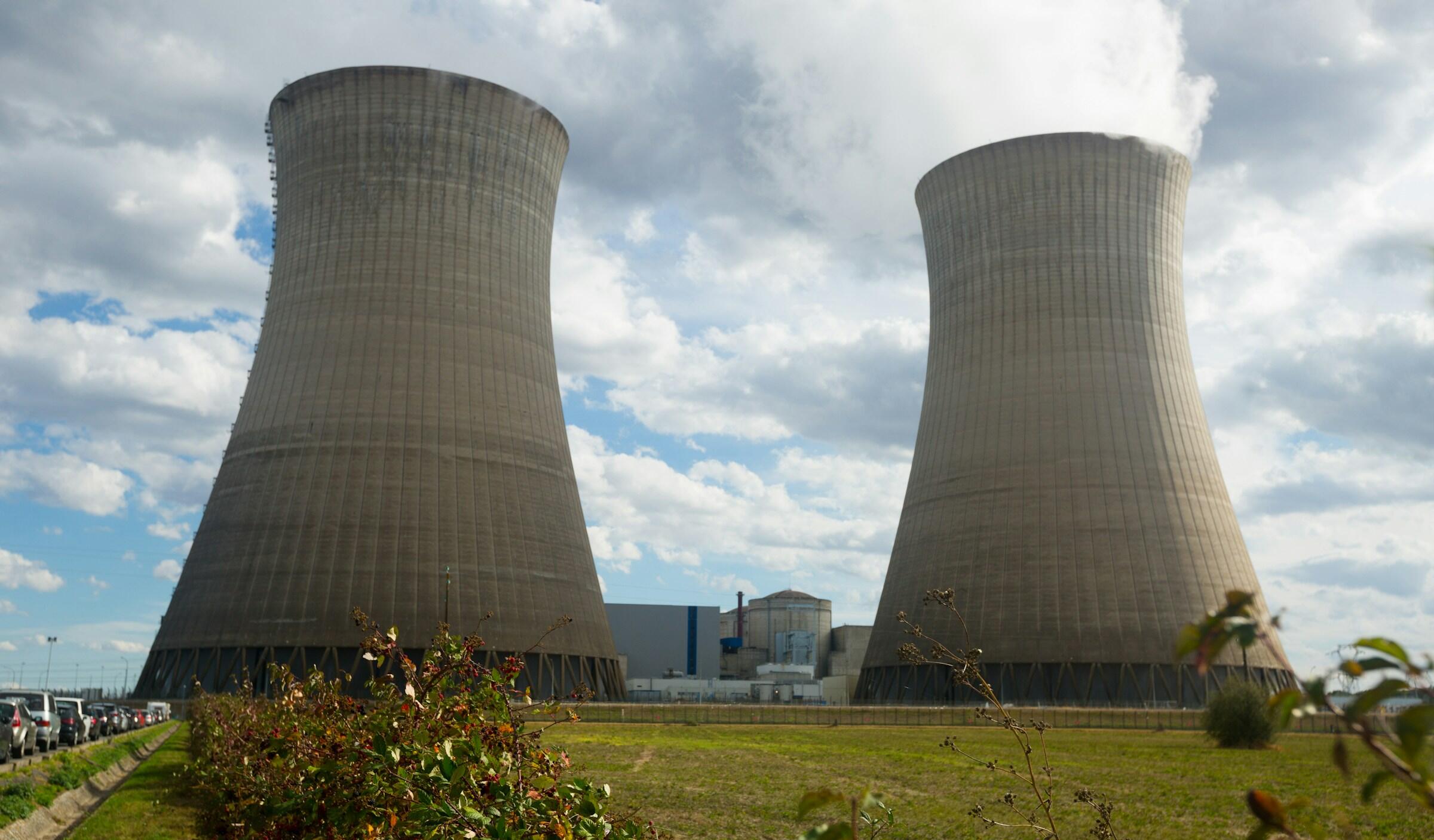 Dos torres de refrigeración de una central eléctrica contra un cielo nublado.