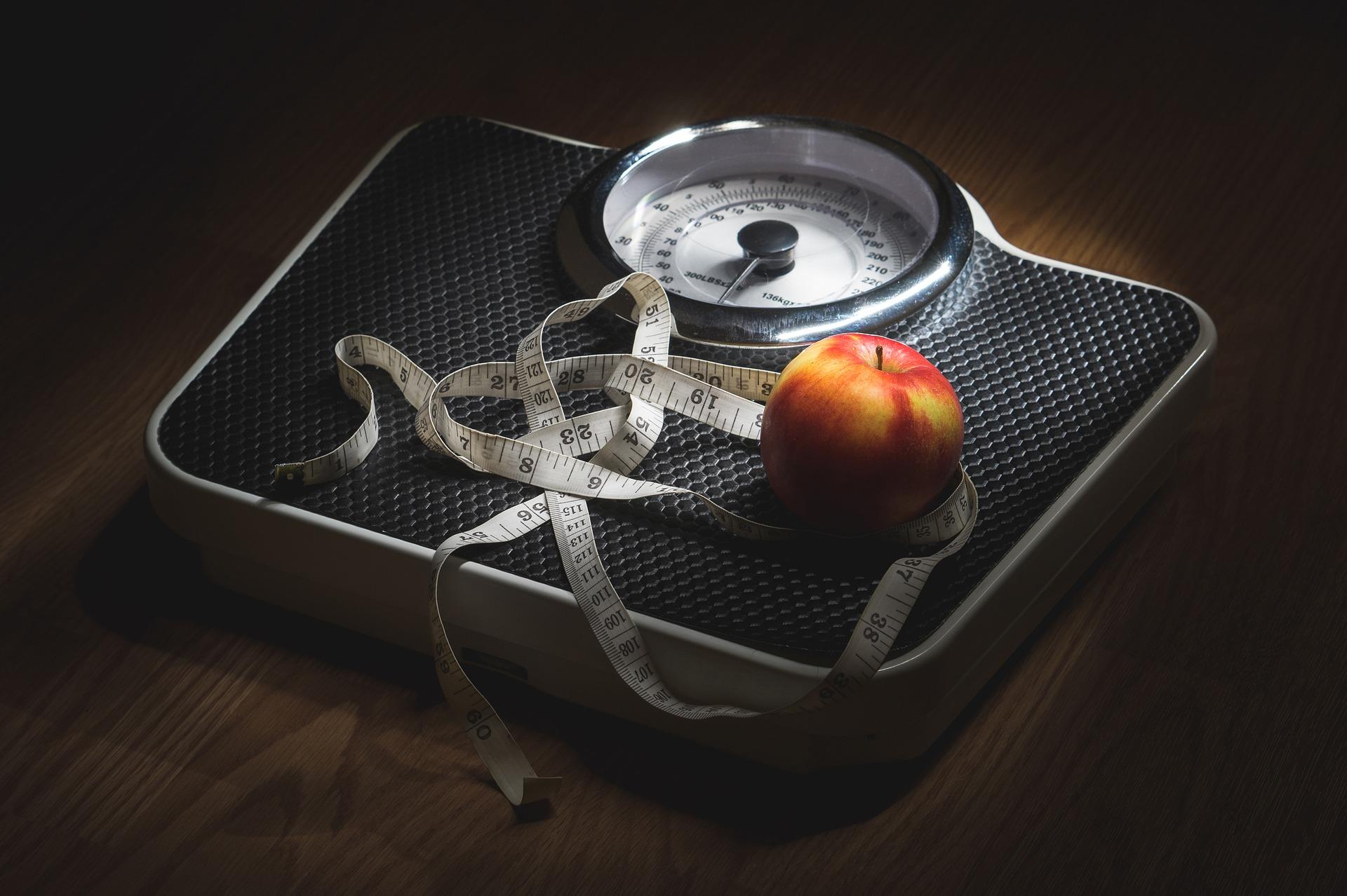 Metro y manzana sobre una pesa