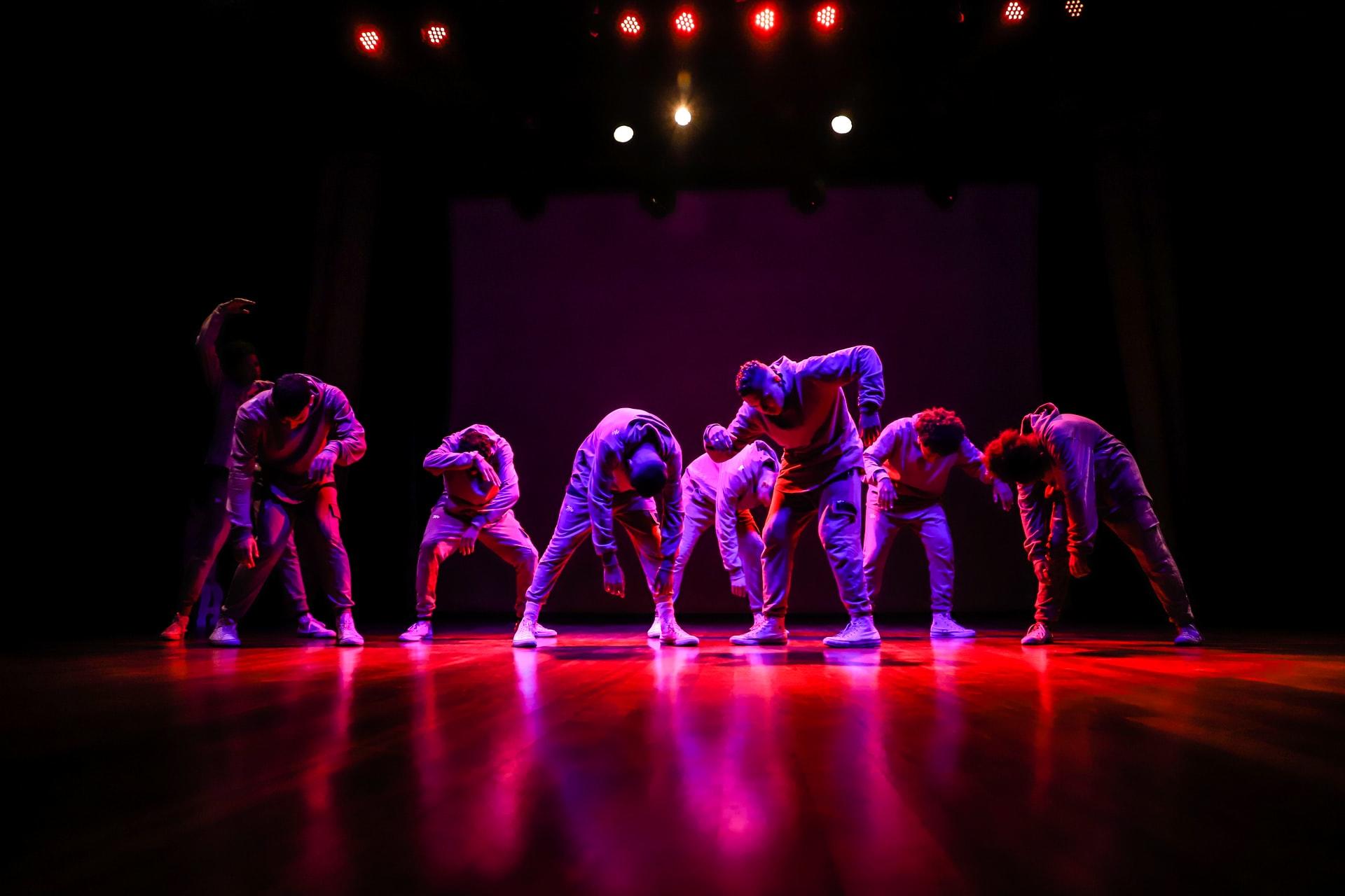 presentación de baile en un escenario con luces rojas