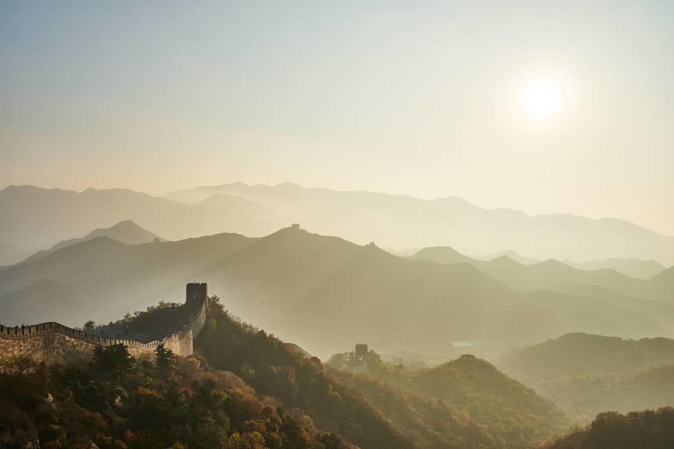 Fotografía artistica de la Gran Muralla China y las montañas que la rodean durante un amanecer.