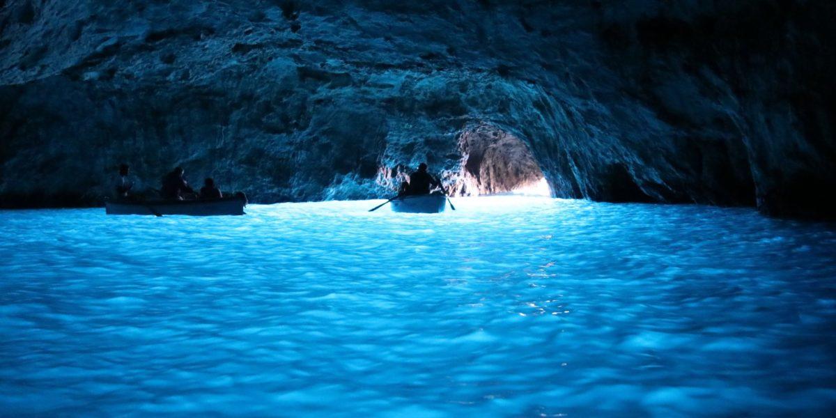 Gruta oscura con el agua azul intenso.