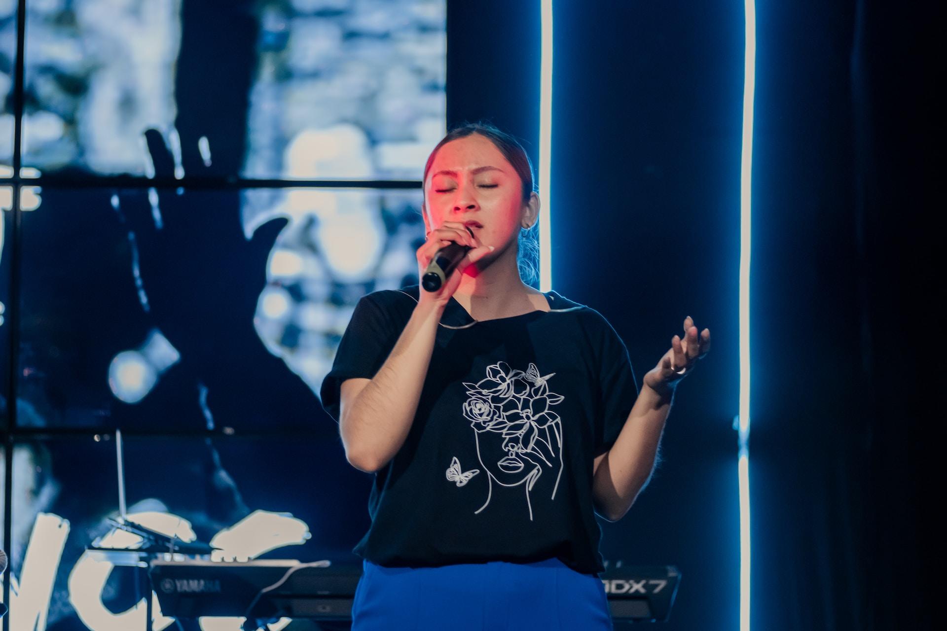Mujer cantando en un escenario.