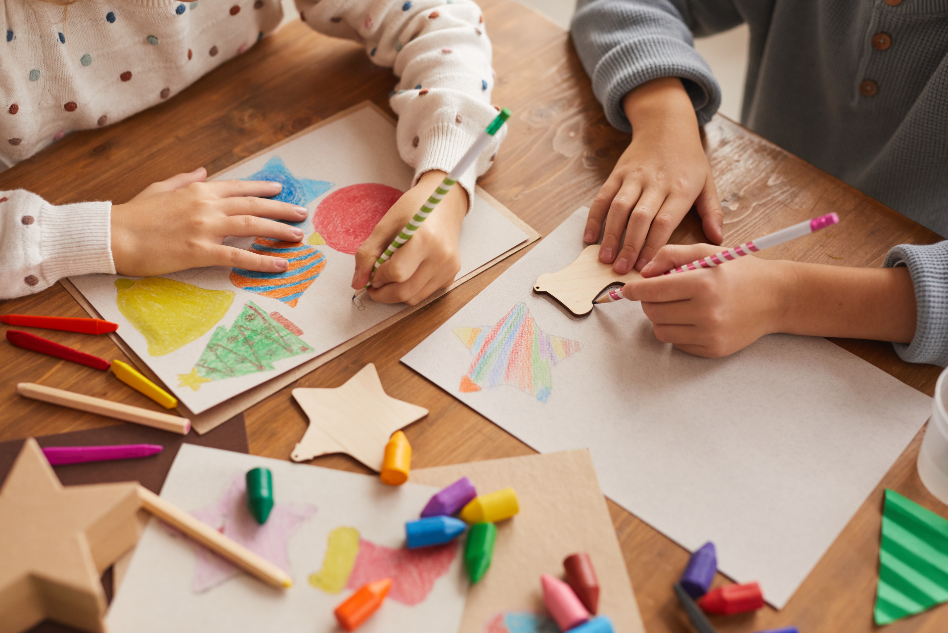 niños utilizando crayones para dibujar figuras