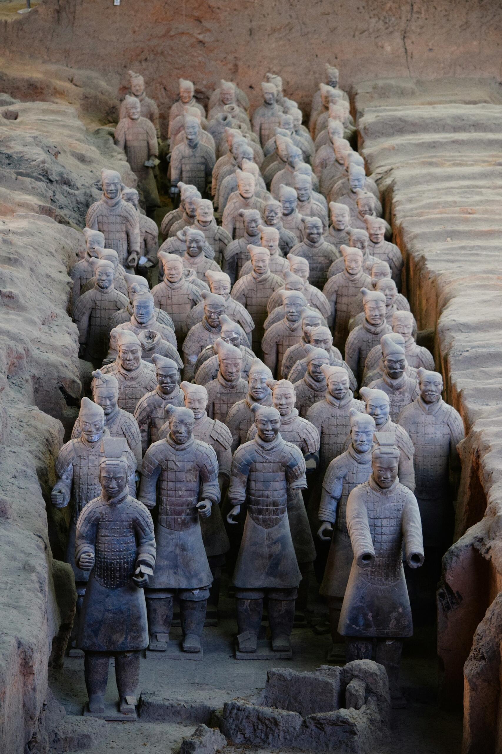 Las estatuas del Ejército de Terracota se alzan en filas dentro de una fosa excavada. Estos antiguos guerreros de arcilla, ataviados con armaduras minuciosamente detalladas, son una muestra de la grandeza histórica.