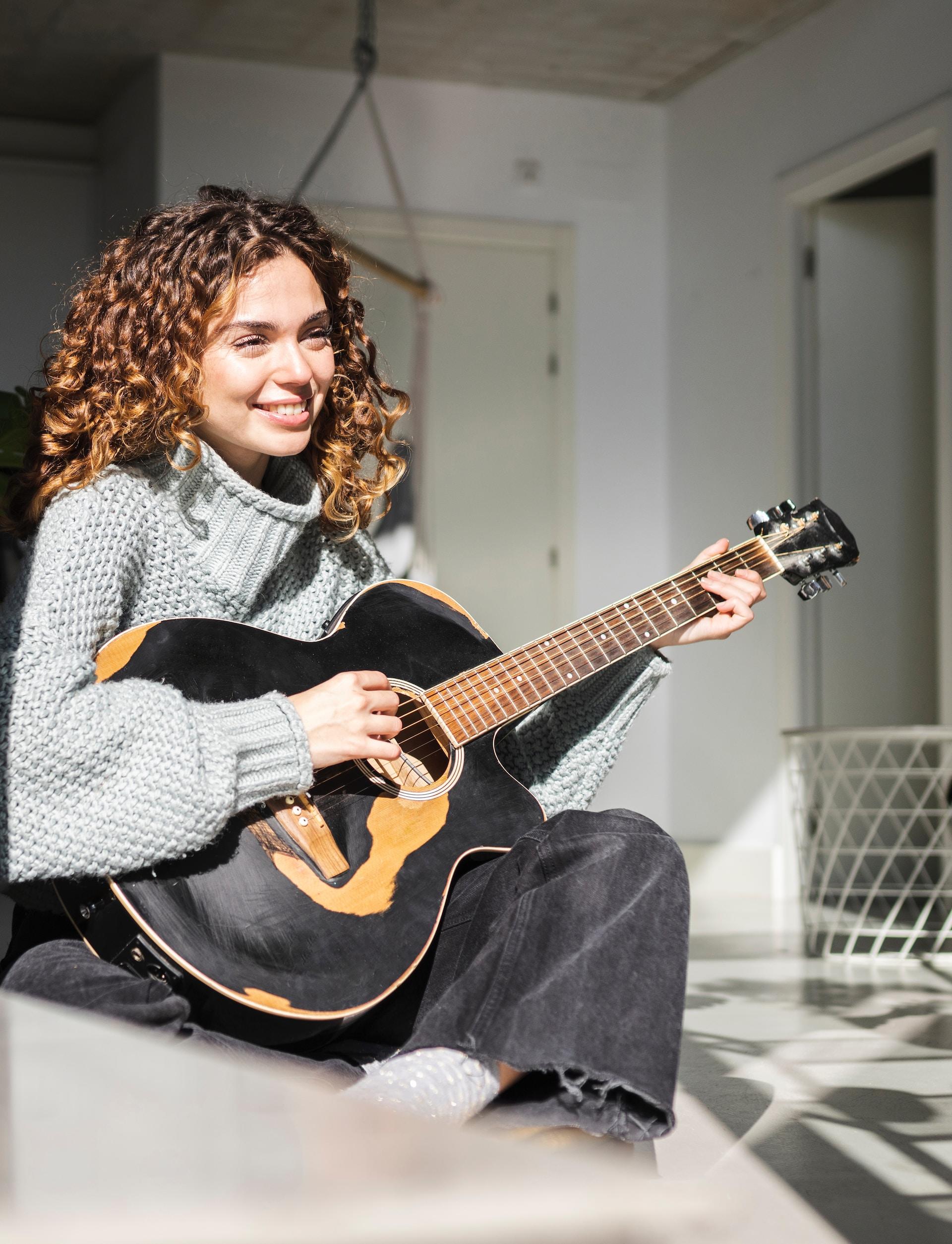 Chica tocando la guitarra.
